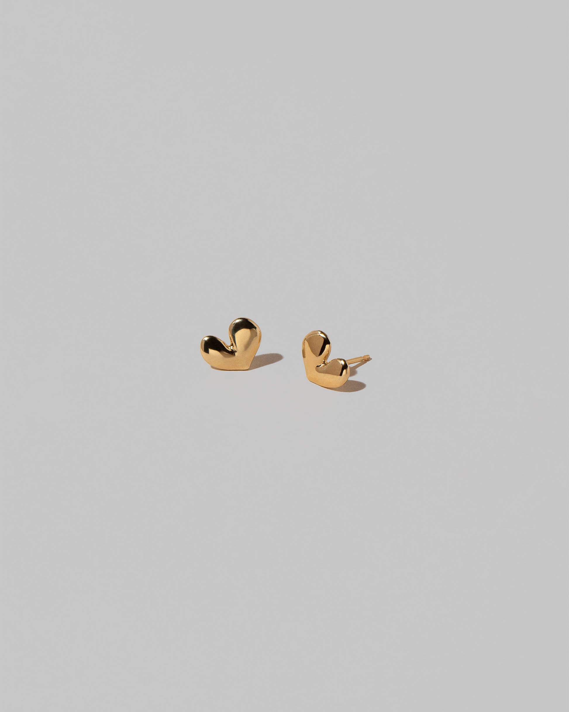 Shape Three Small Thousand & One Night Heart Stud Earrings on light color background.