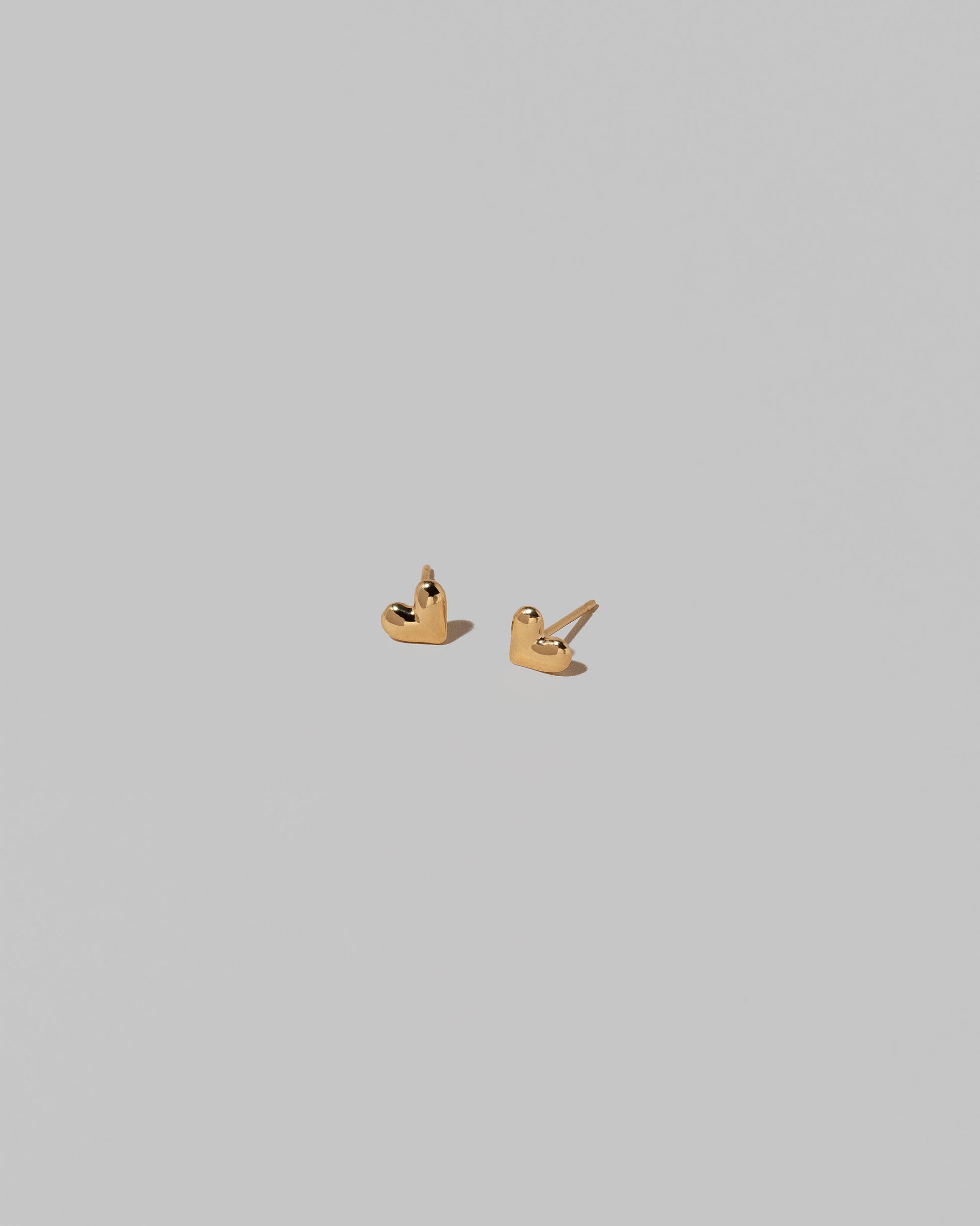 Shape Four Small Thousand & One Night Heart Stud Earrings on light color background.