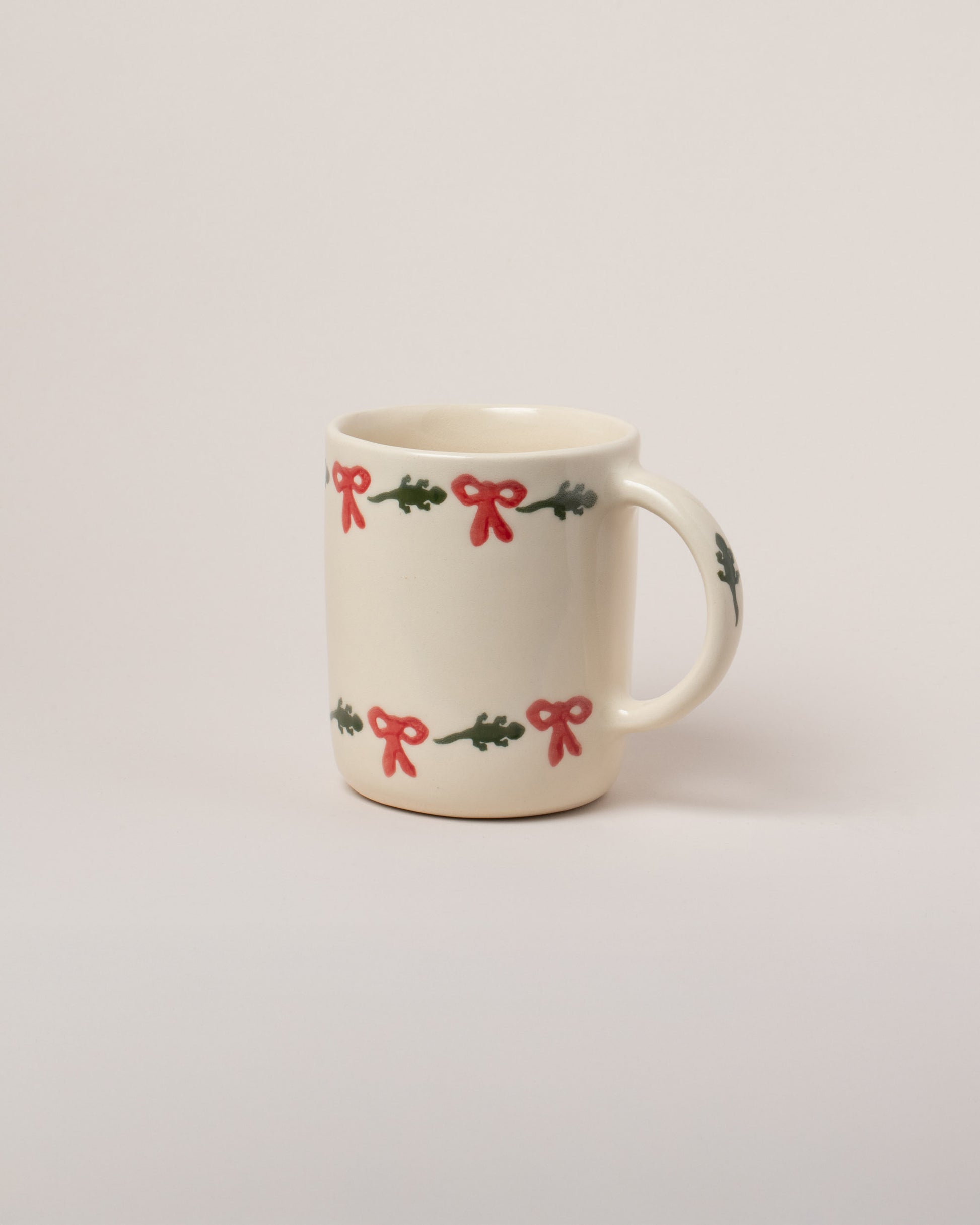 Helen Levi Lizard Holiday Mug on light color background.
