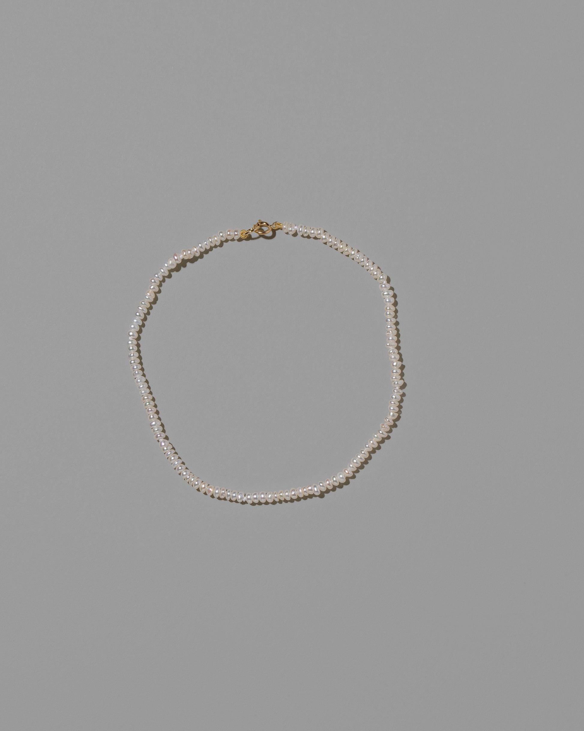 White Pebble Seed Pearl Anklet on light color background.