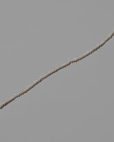 Closeup details of the White Pebble Seed Pearl Choker Necklace on light color background.