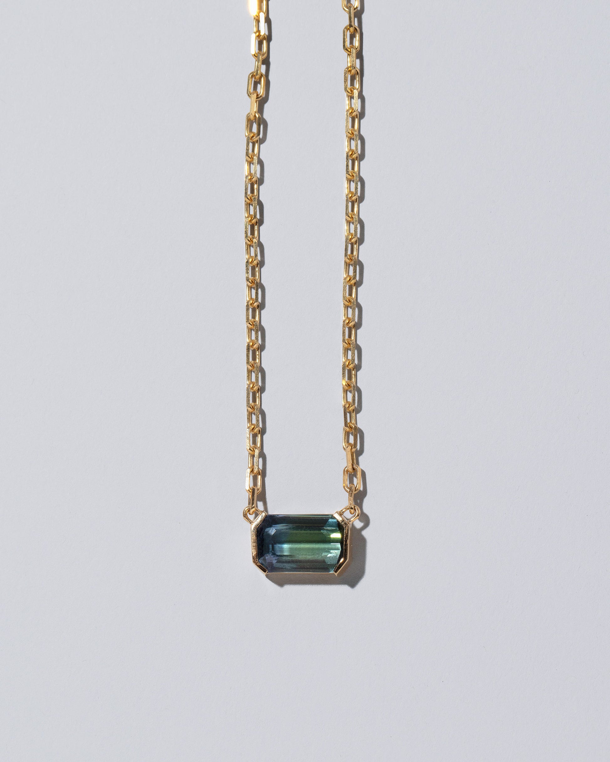 Closeup details of the Attunement Necklace on light color background.