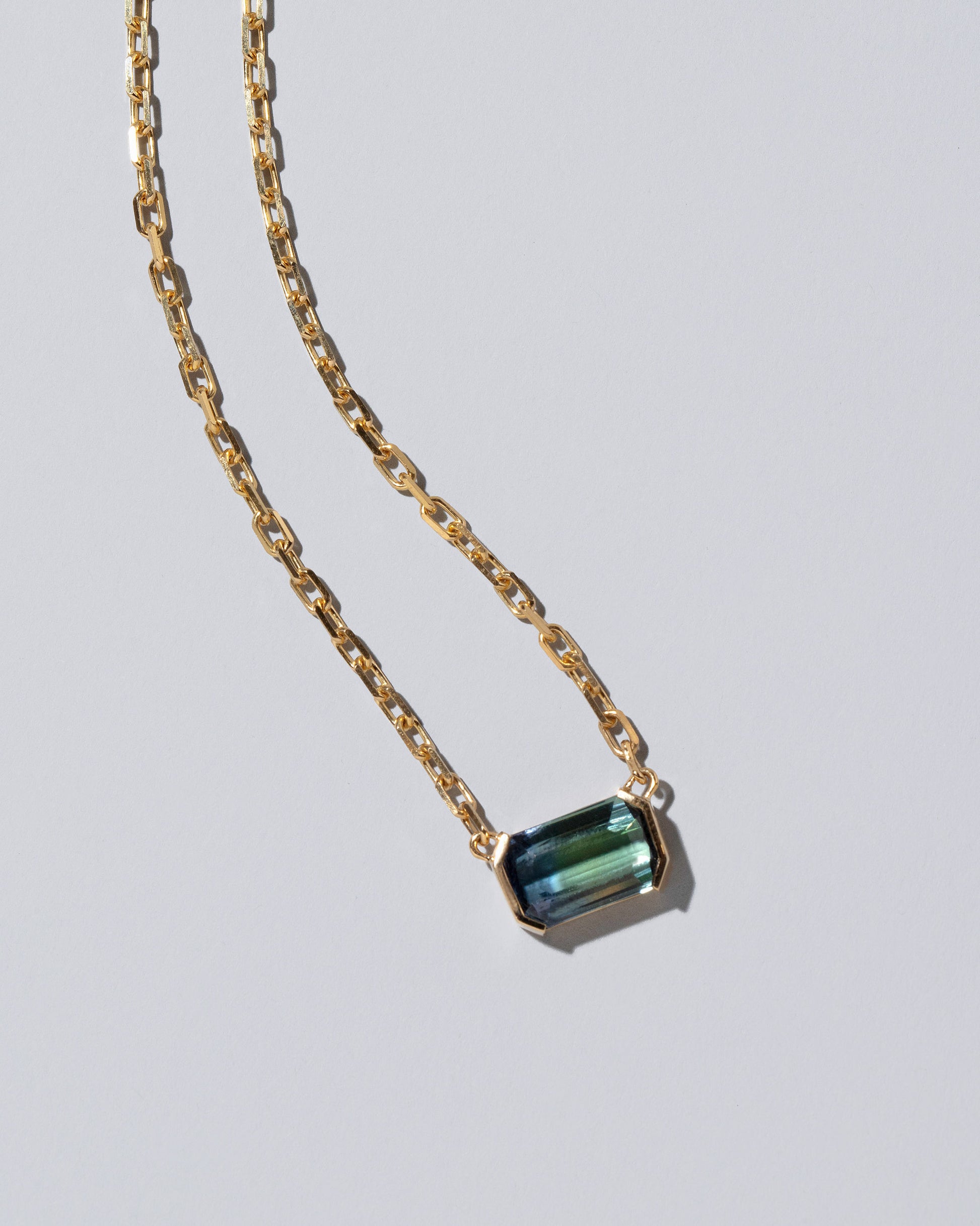 Closeup details of the Attunement Necklace on light color background.