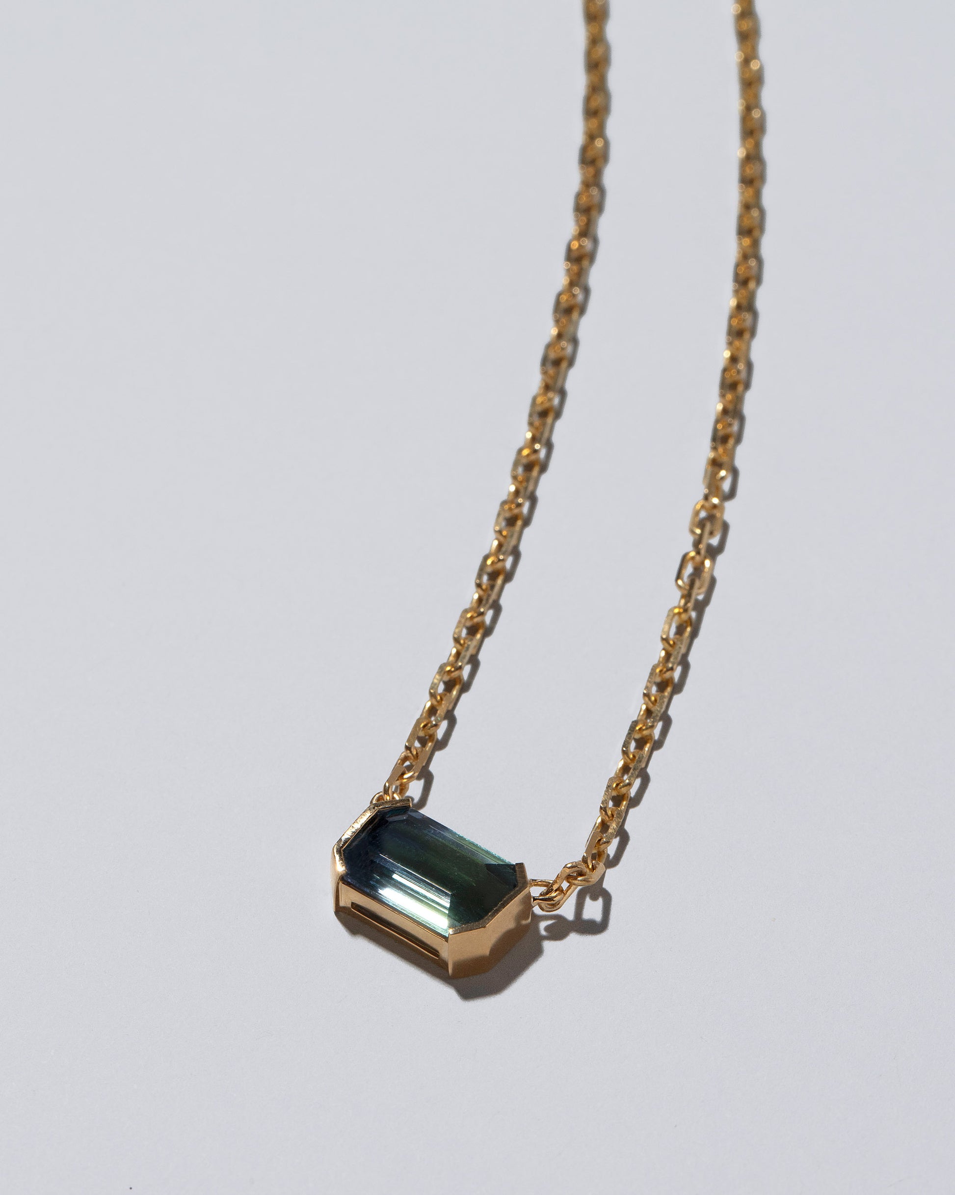 Closeup details of the Attunement Necklace on light color background.