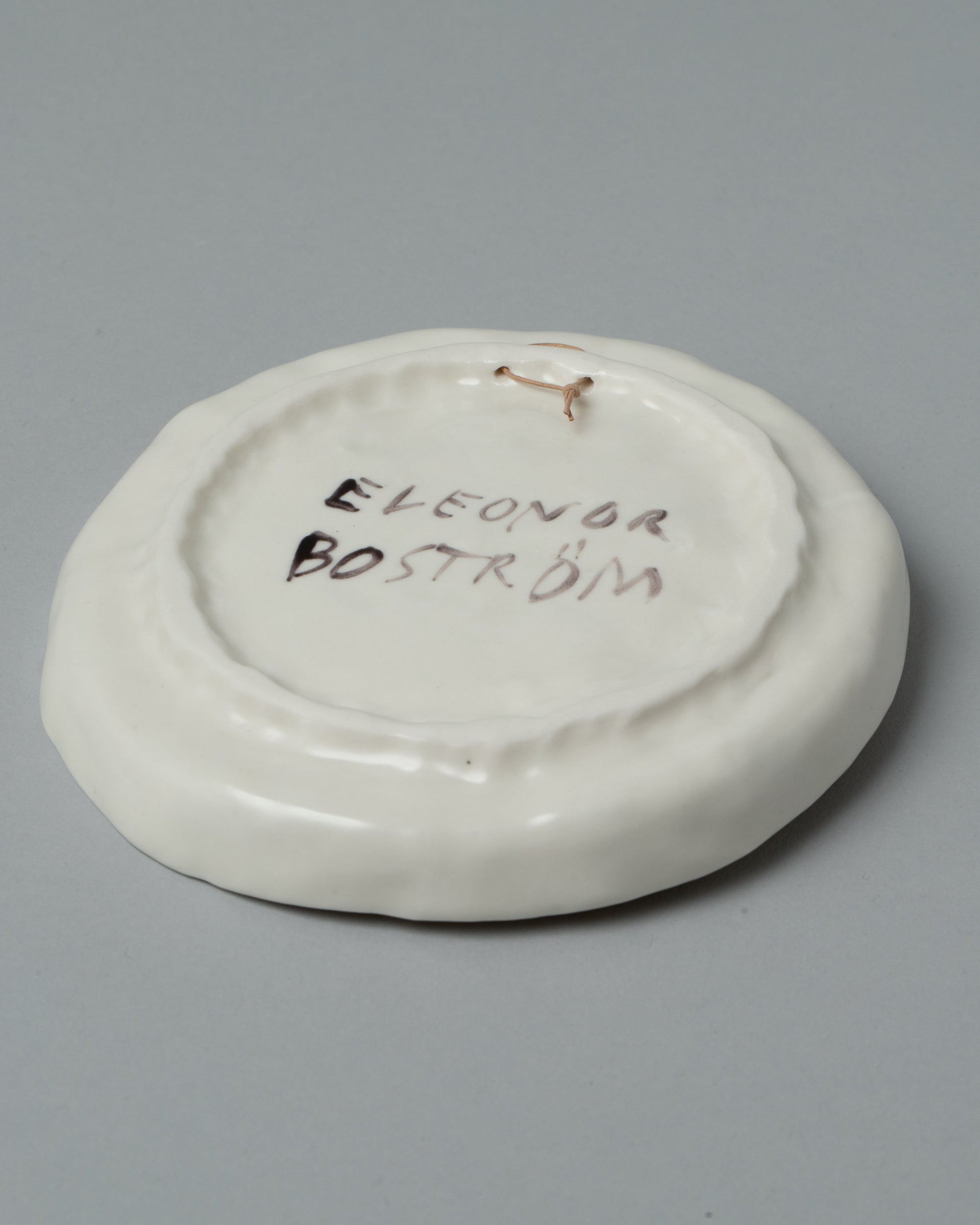 View from the back of the Eleonor Boström Hanging Dog Dish on light color background.