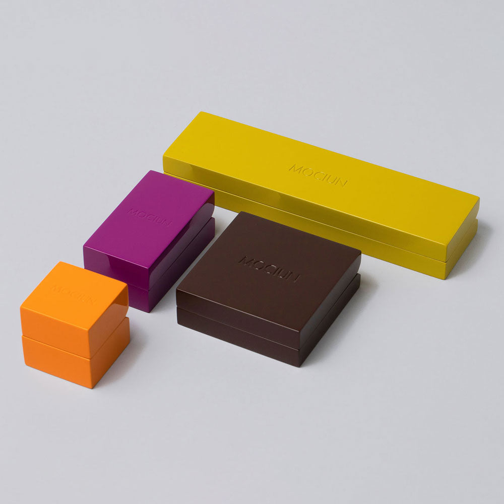 product_details::Group of Orange, Purple, Brown and Green Lacquer Boxes on light color background.