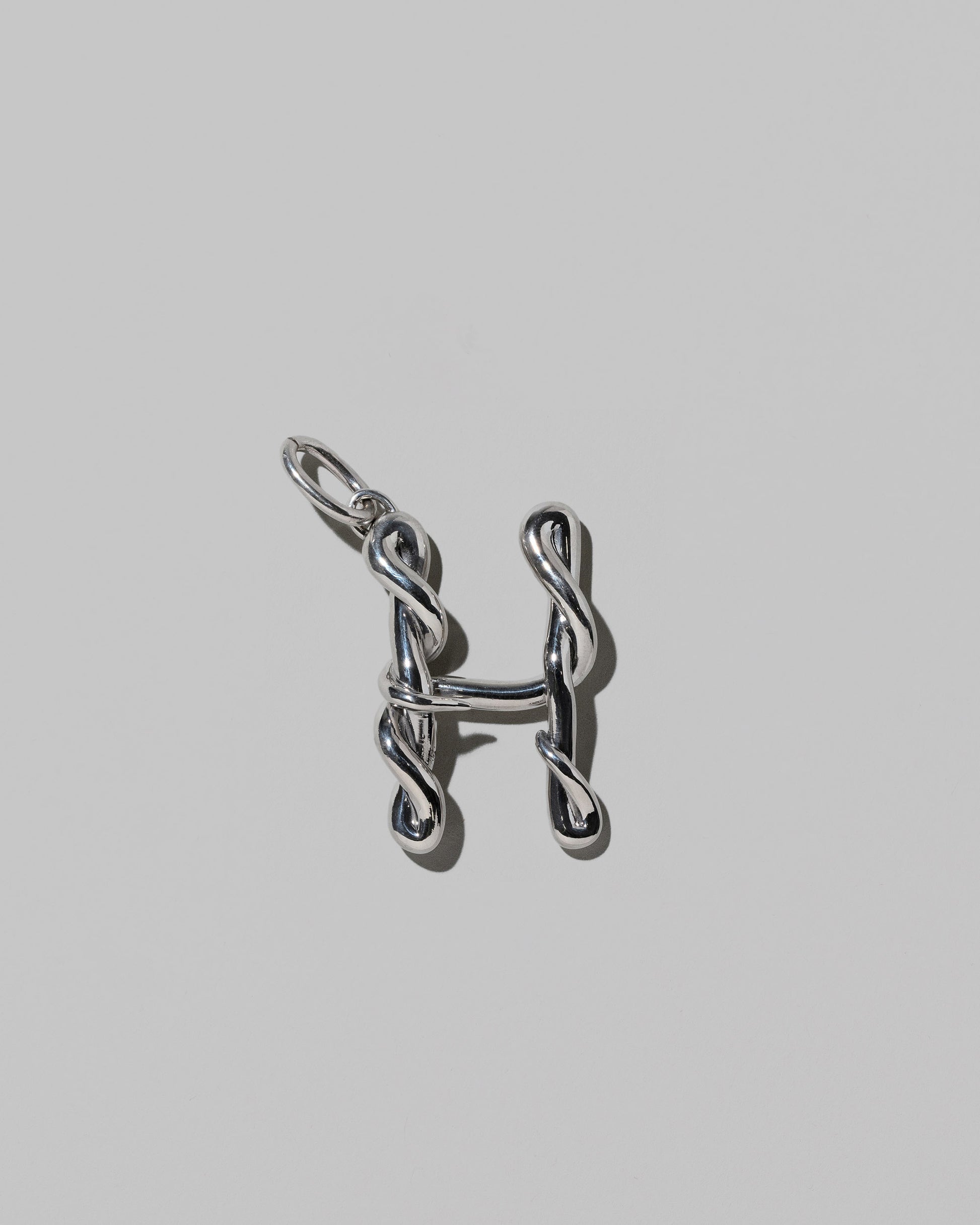 CRZM Large Letter H Charm set in sterling silver on light color background.