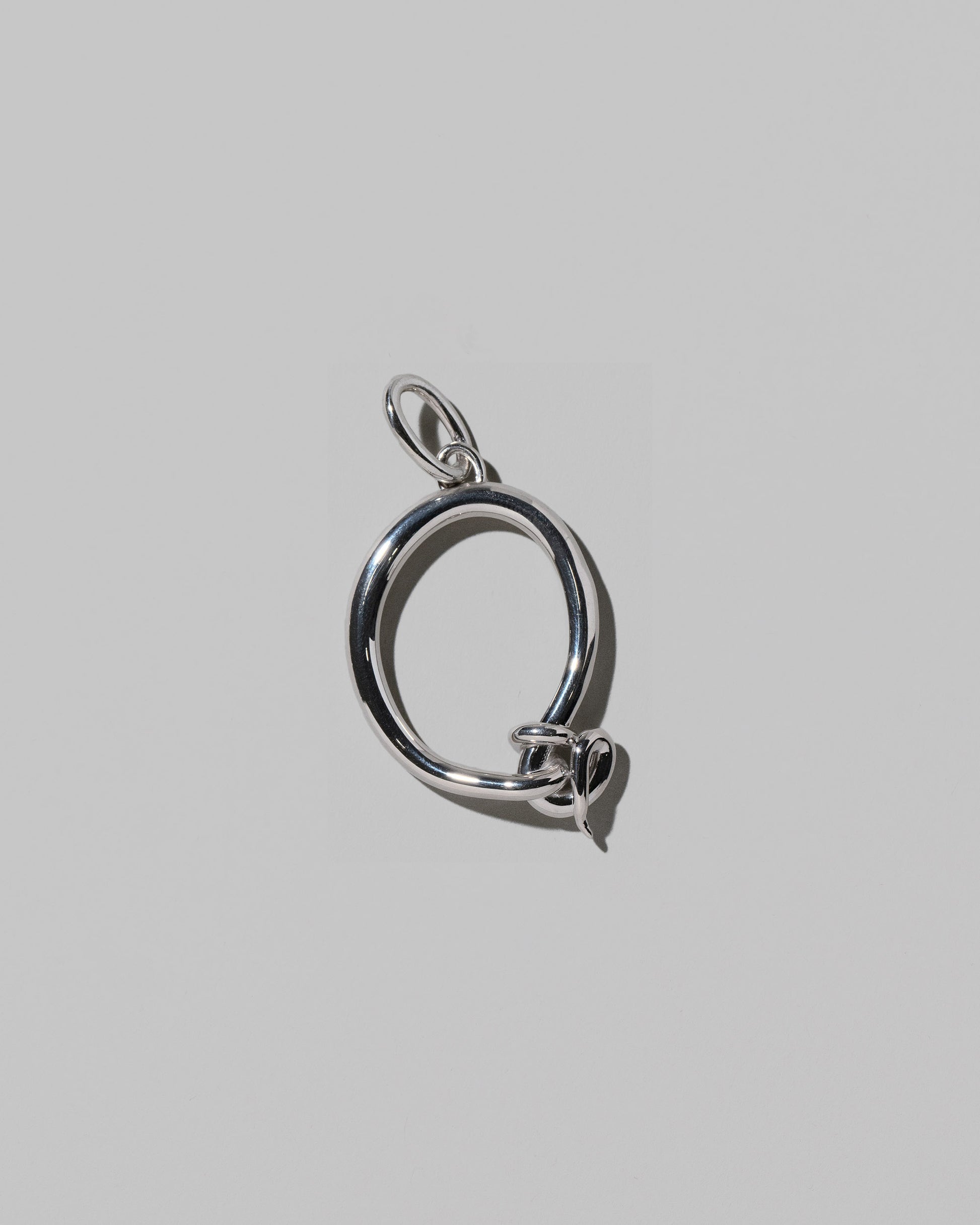 CRZM Large Letter Q Charm set in sterling silver on light color background.