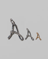 CRZM Large Sterling Silver, Medium Sterling Silver & Mini Letter A Charms set in solid gold on light color background.