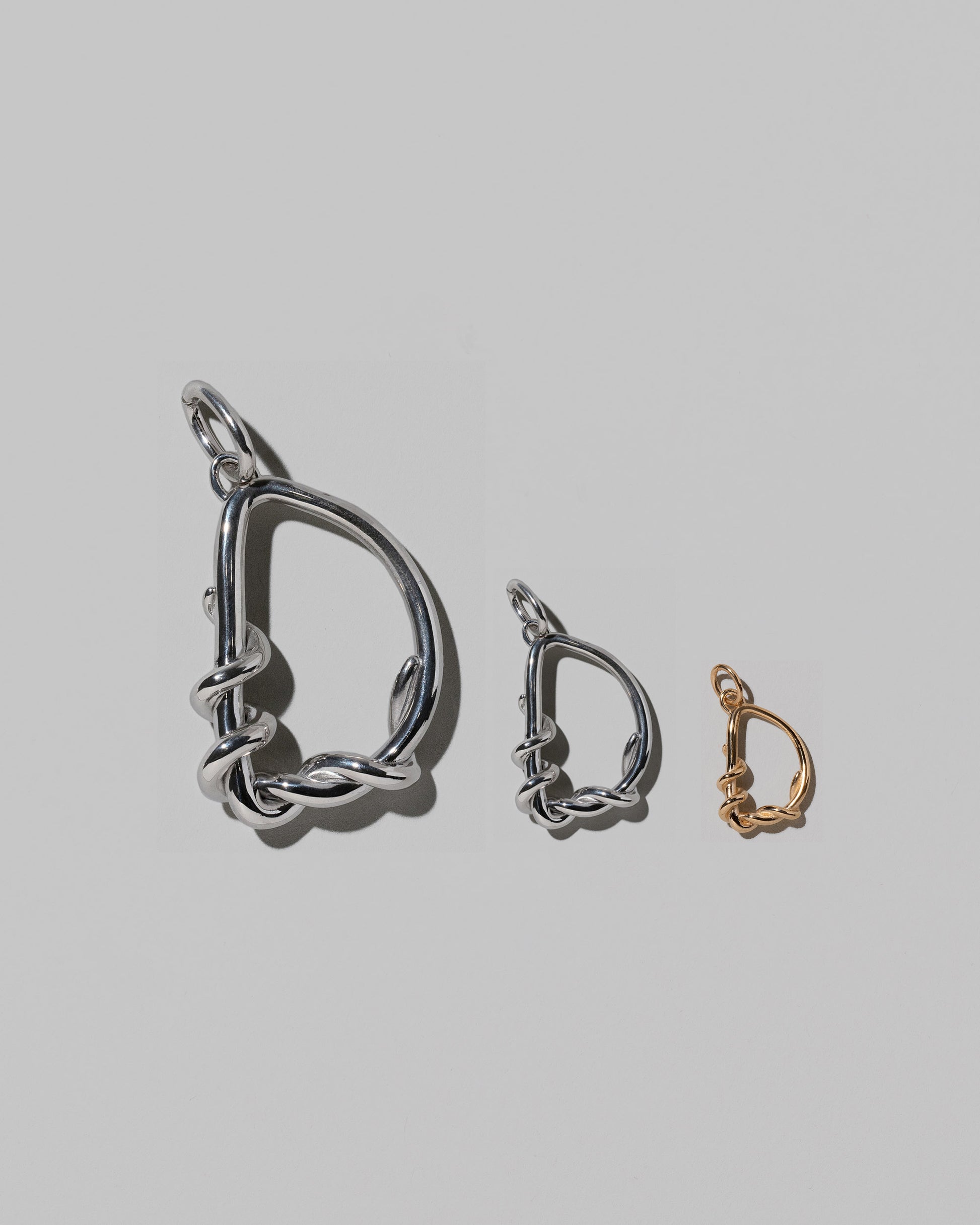 CRZM Large Sterling Silver, Medium Sterling Silver & Mini Letter D Charms set in solid gold on light color background.