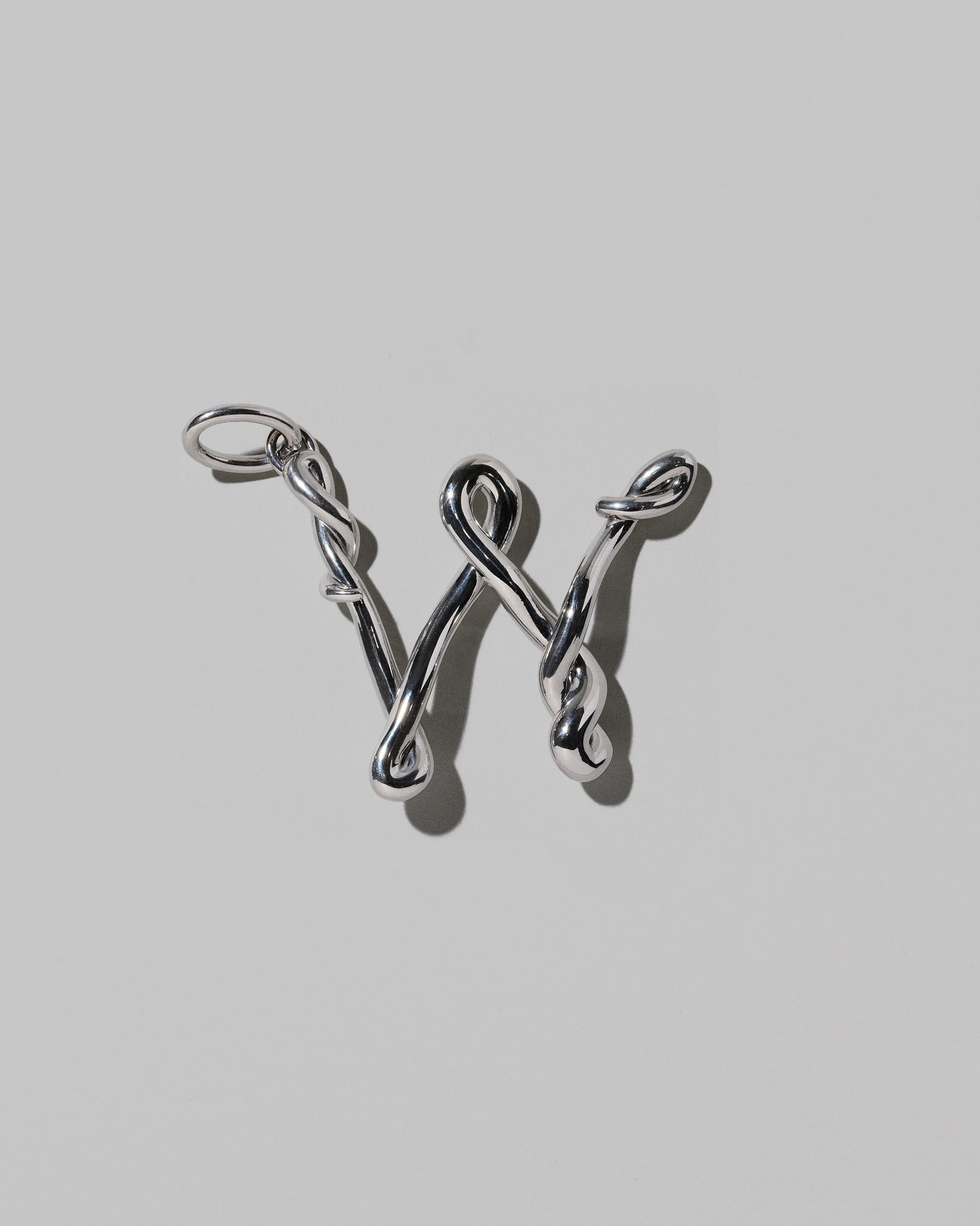CRZM Large Letter W Charm set in sterling silver on light color background.