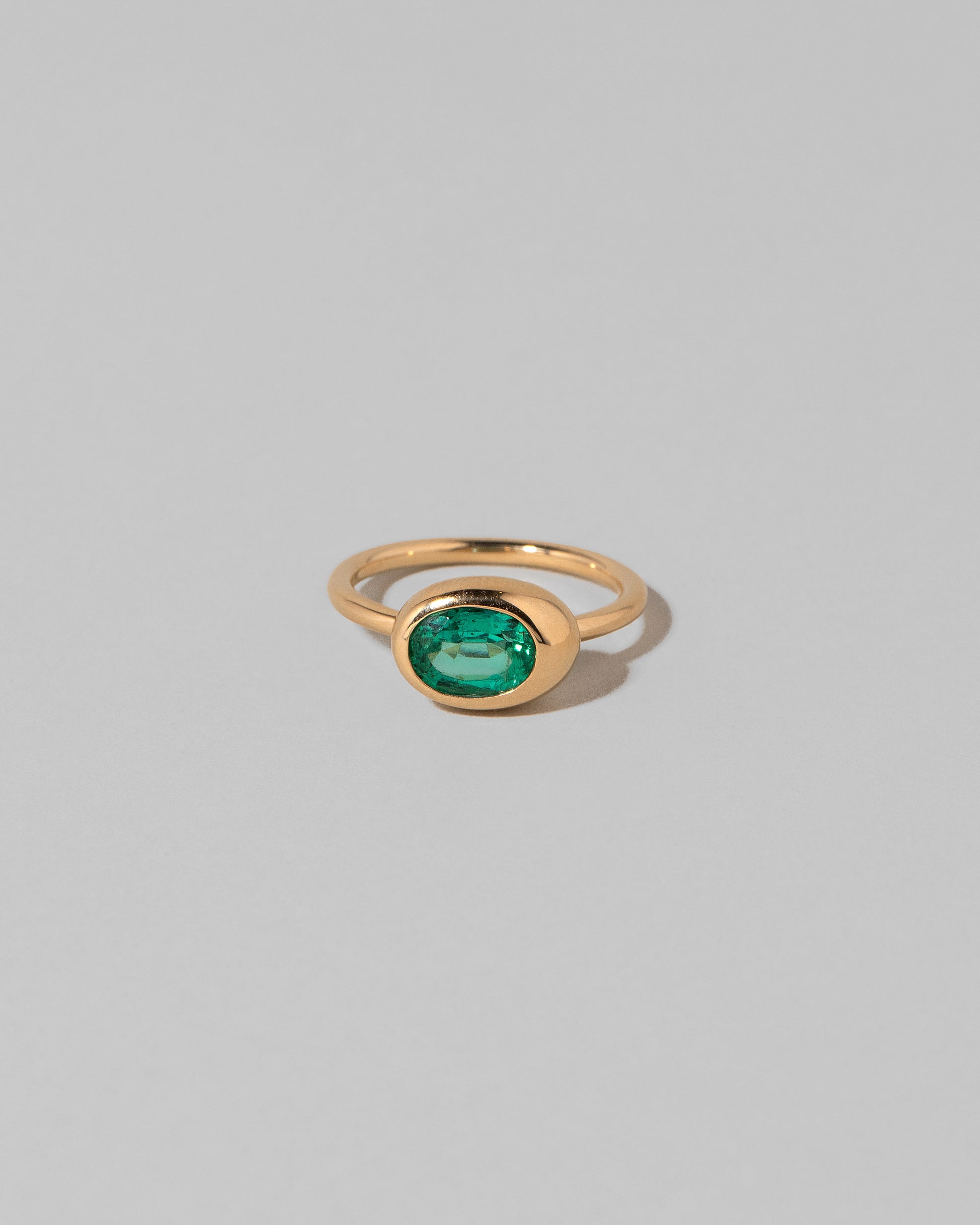 Oval Emerald Equalize Ring on light color background.