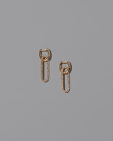 Pavé Link Huggie Hoop Earrings on light color background.