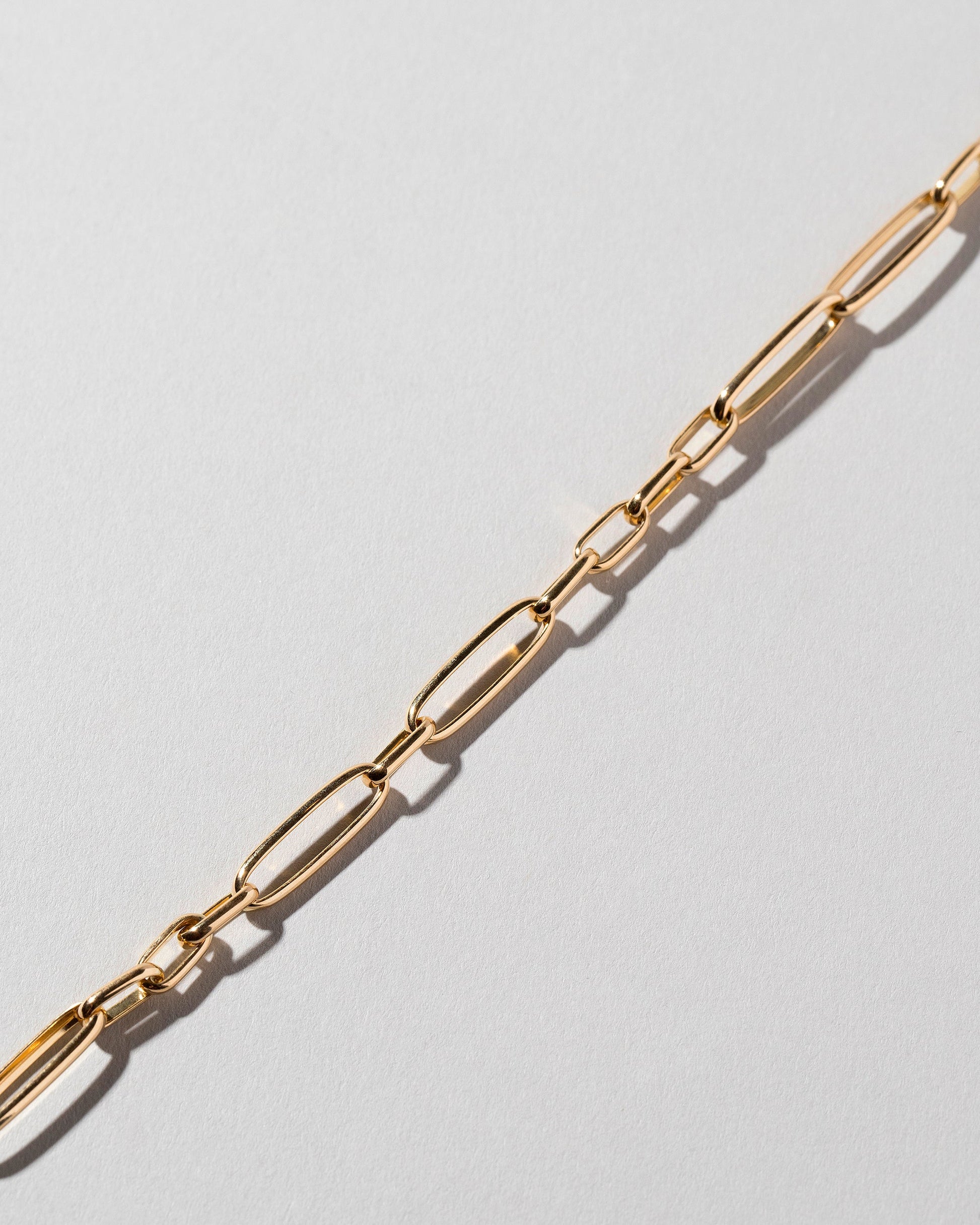 Closeup details of the Long Loop Chain Bracelet on light color background.