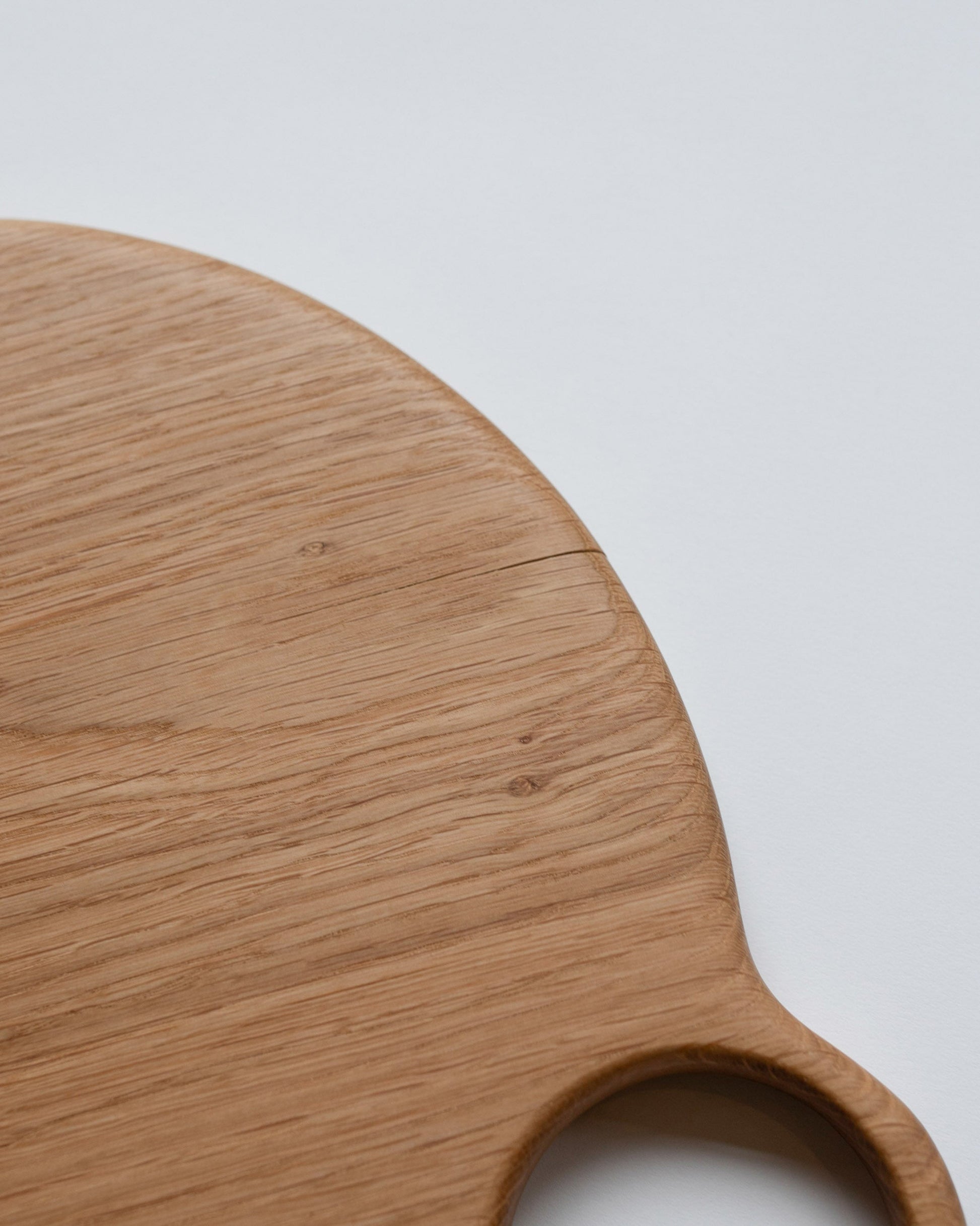 Closeup details of the Lucas Castex No. 10 Hand-Carved Oak Wood Serving Board on light color background.