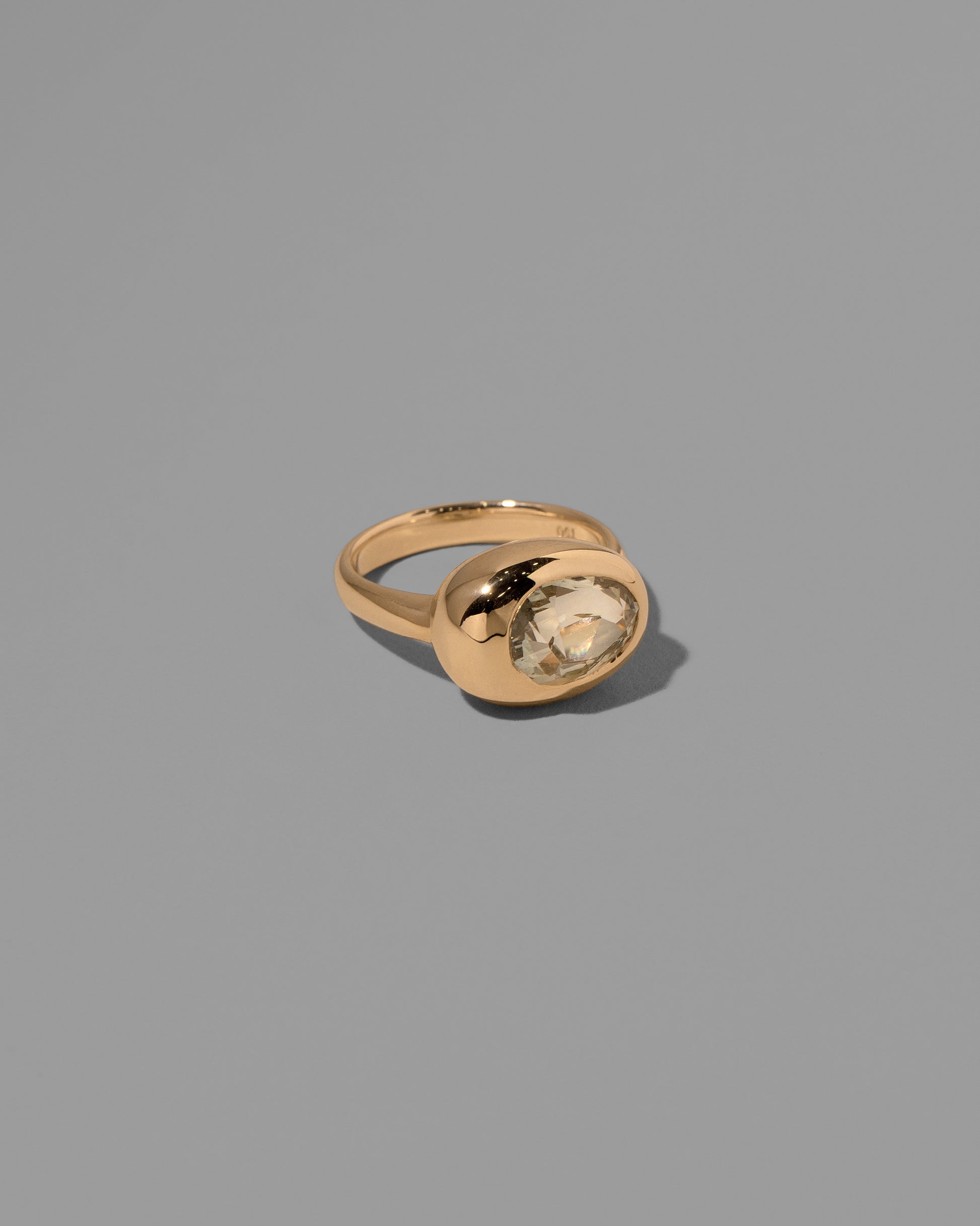 View from the side of the past version of the Sapphire Grand Align Ring on light color background.