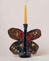 Detail view of the Maggie Boyd Moth To The Flame Candle Holder on light color background.