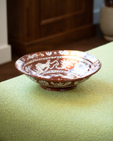 Maggie Boyd Extra Large Chocolate Flower Lickers Bowl on chaise.