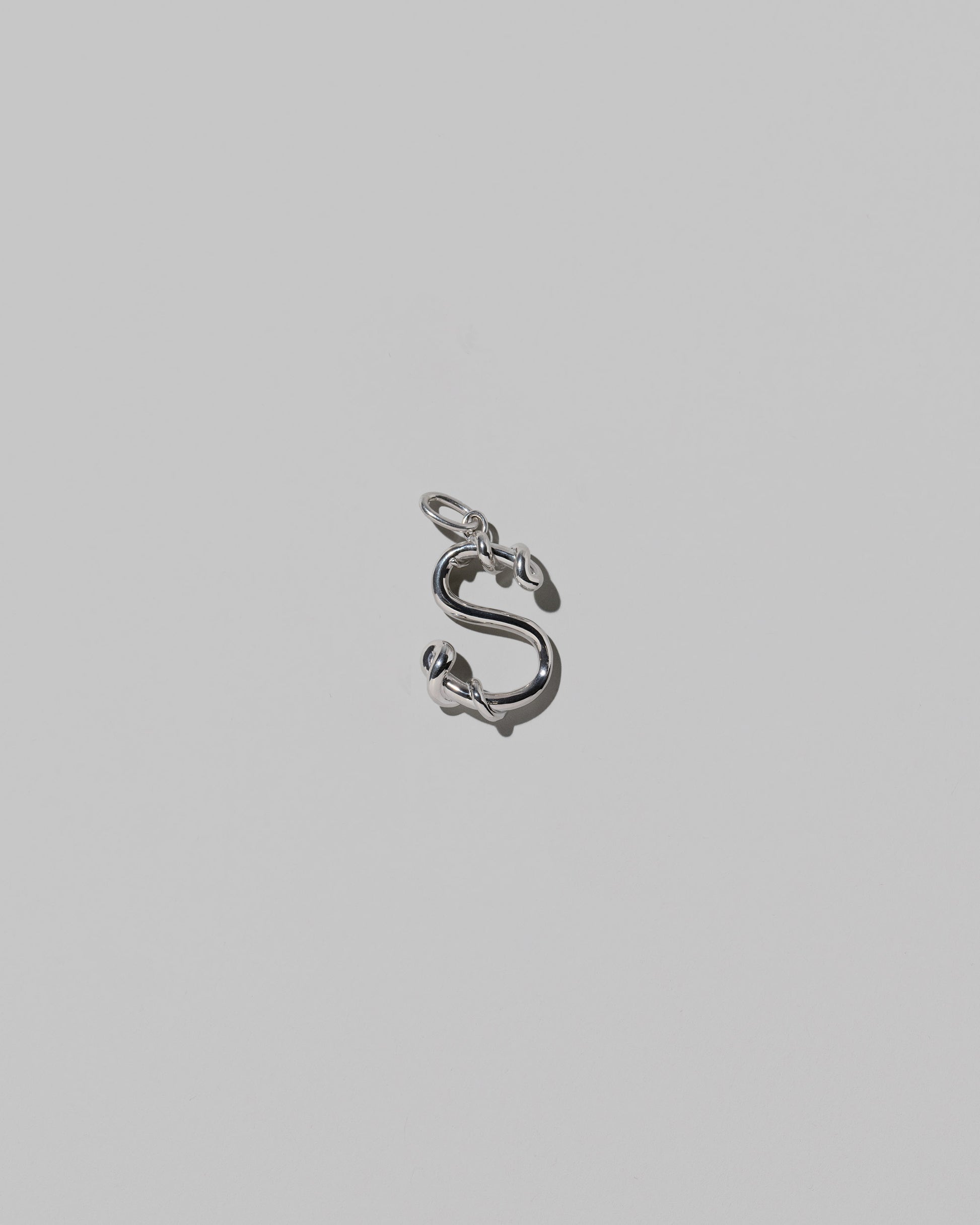 CRZM Medium Letter S Charm set in sterling silver on light color background.