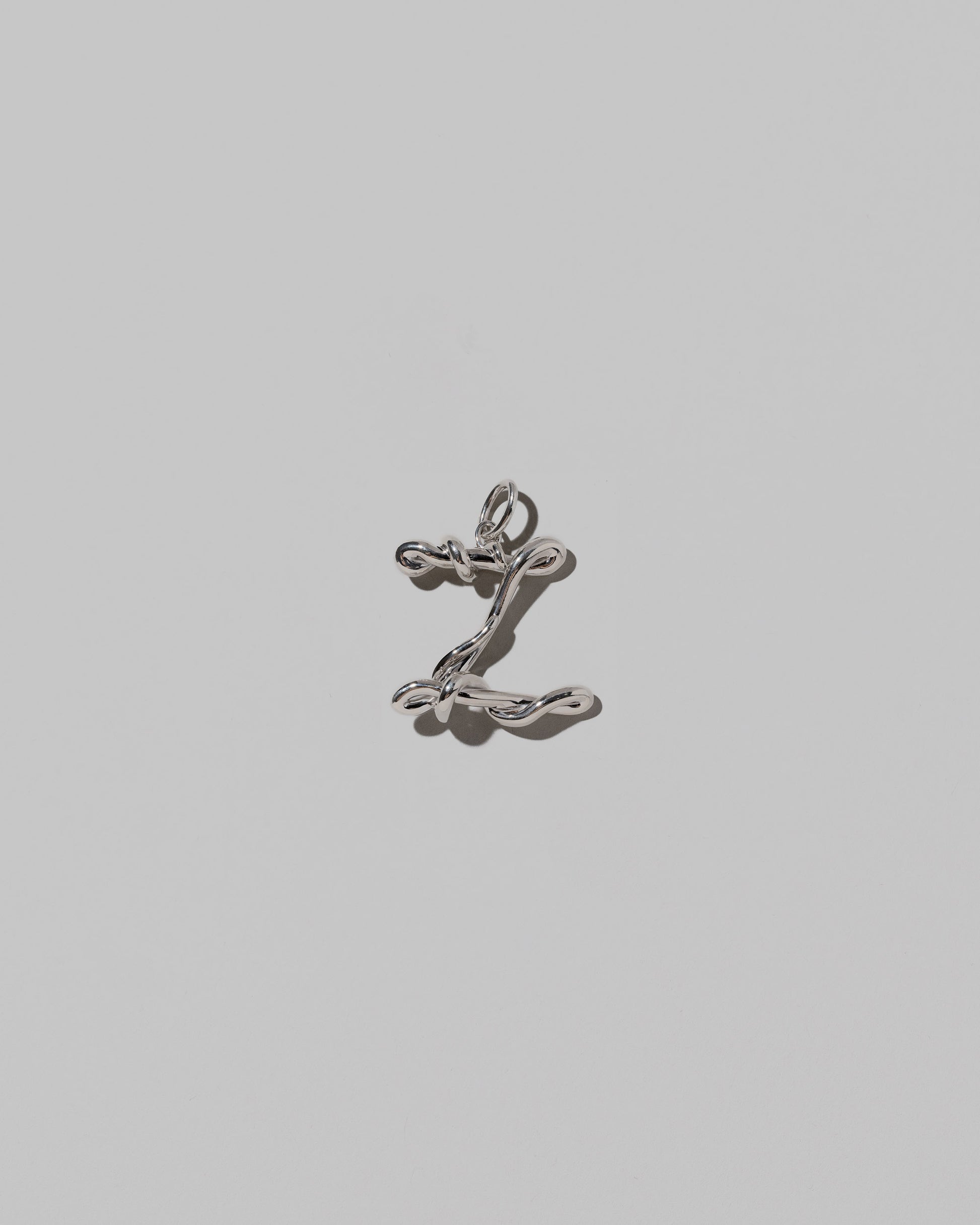CRZM Medium Letter Z Charm set in sterling silver on light color background.