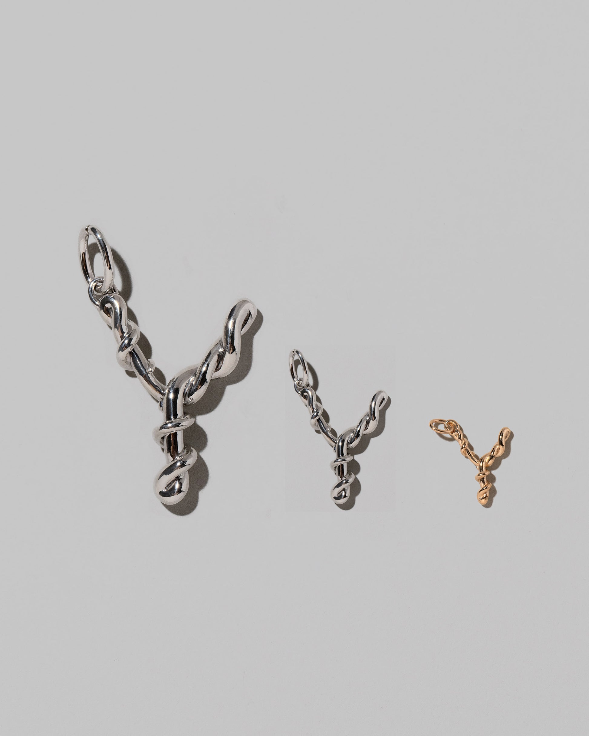 CRZM Large Sterling Silver, Medium Sterling Silver & Mini Letter Y Charms set in solid gold on light color background.