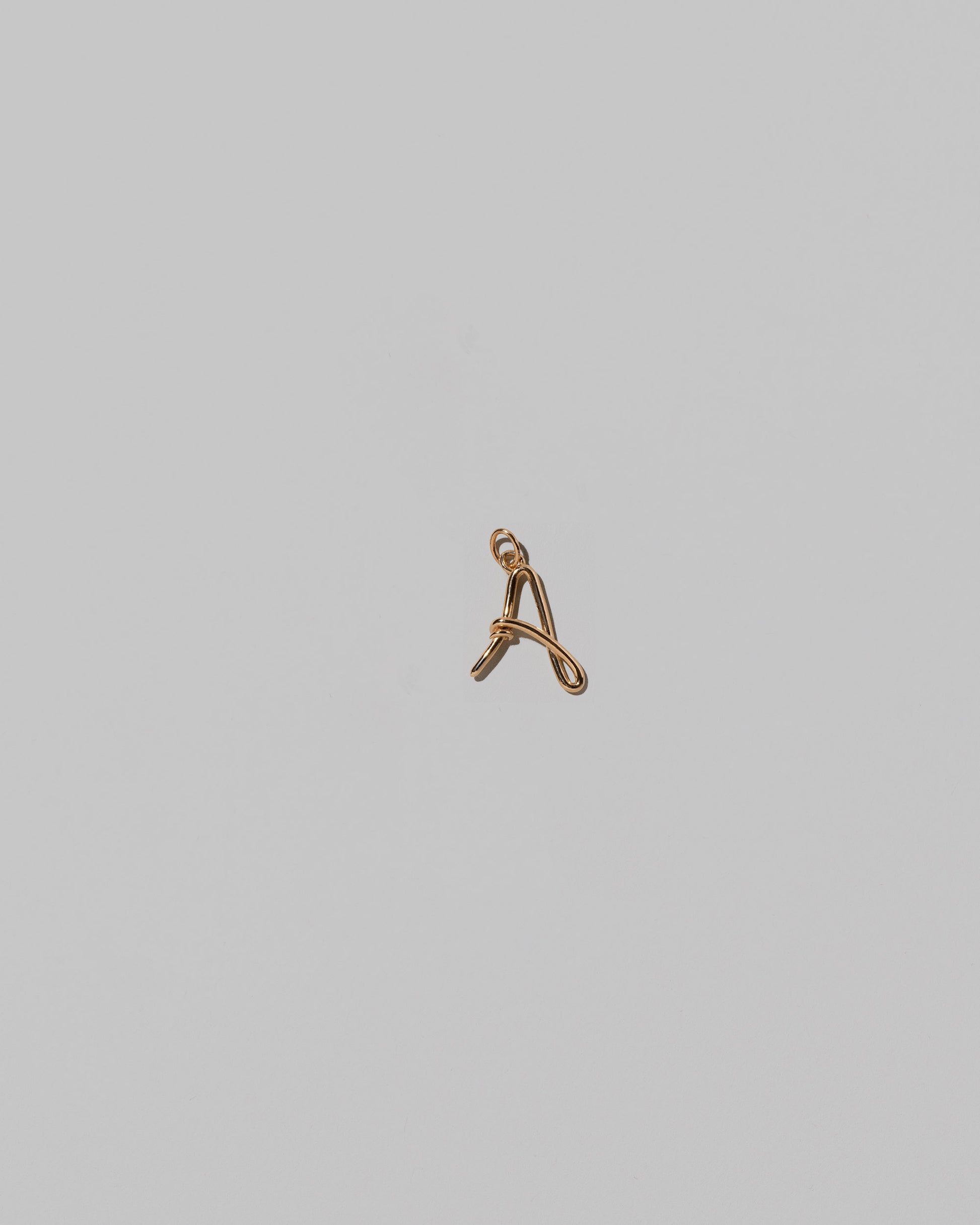 CRZM Mini Letter A set in solid gold on light color background.