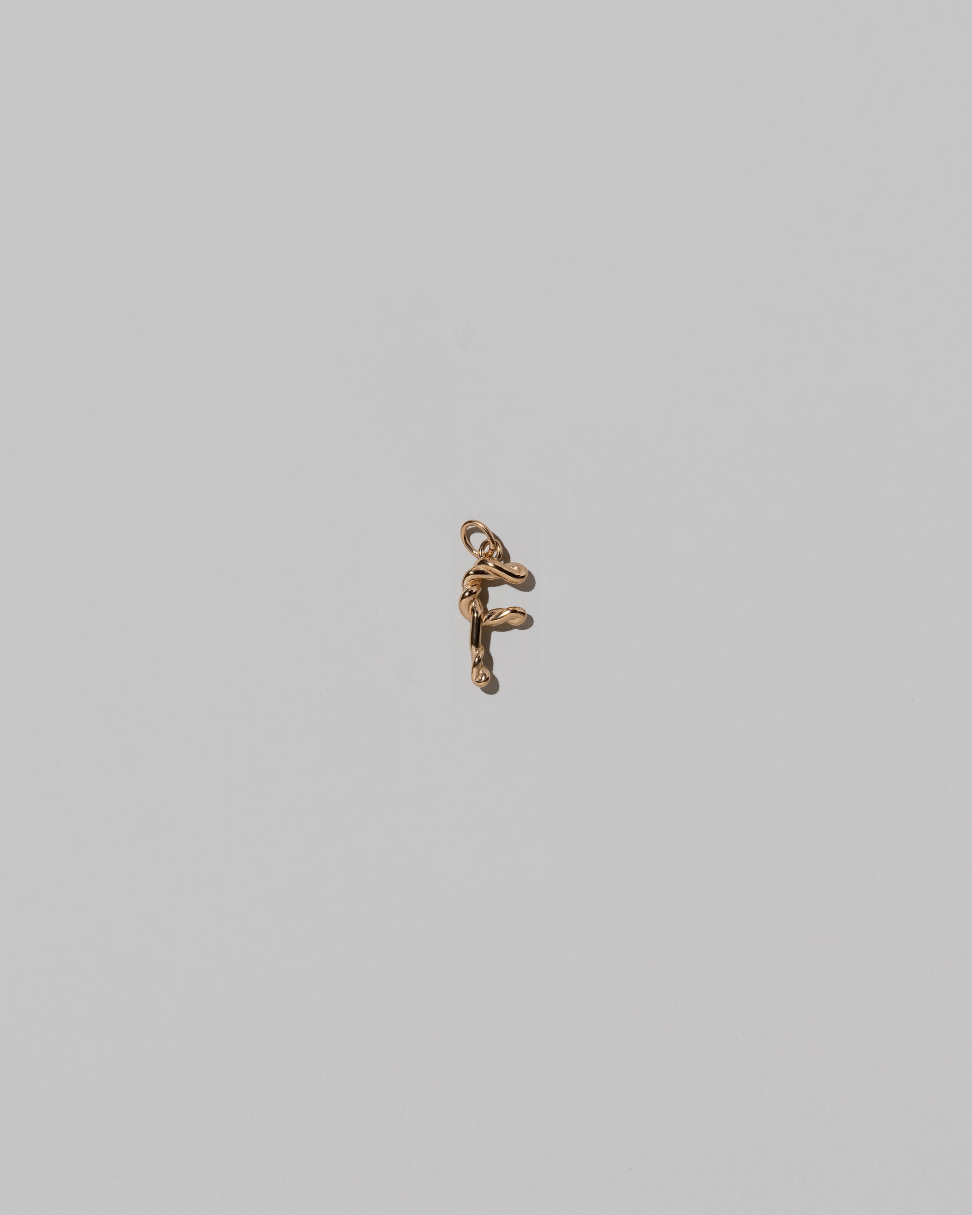 CRZM Mini Letter F set in solid gold on light color background.