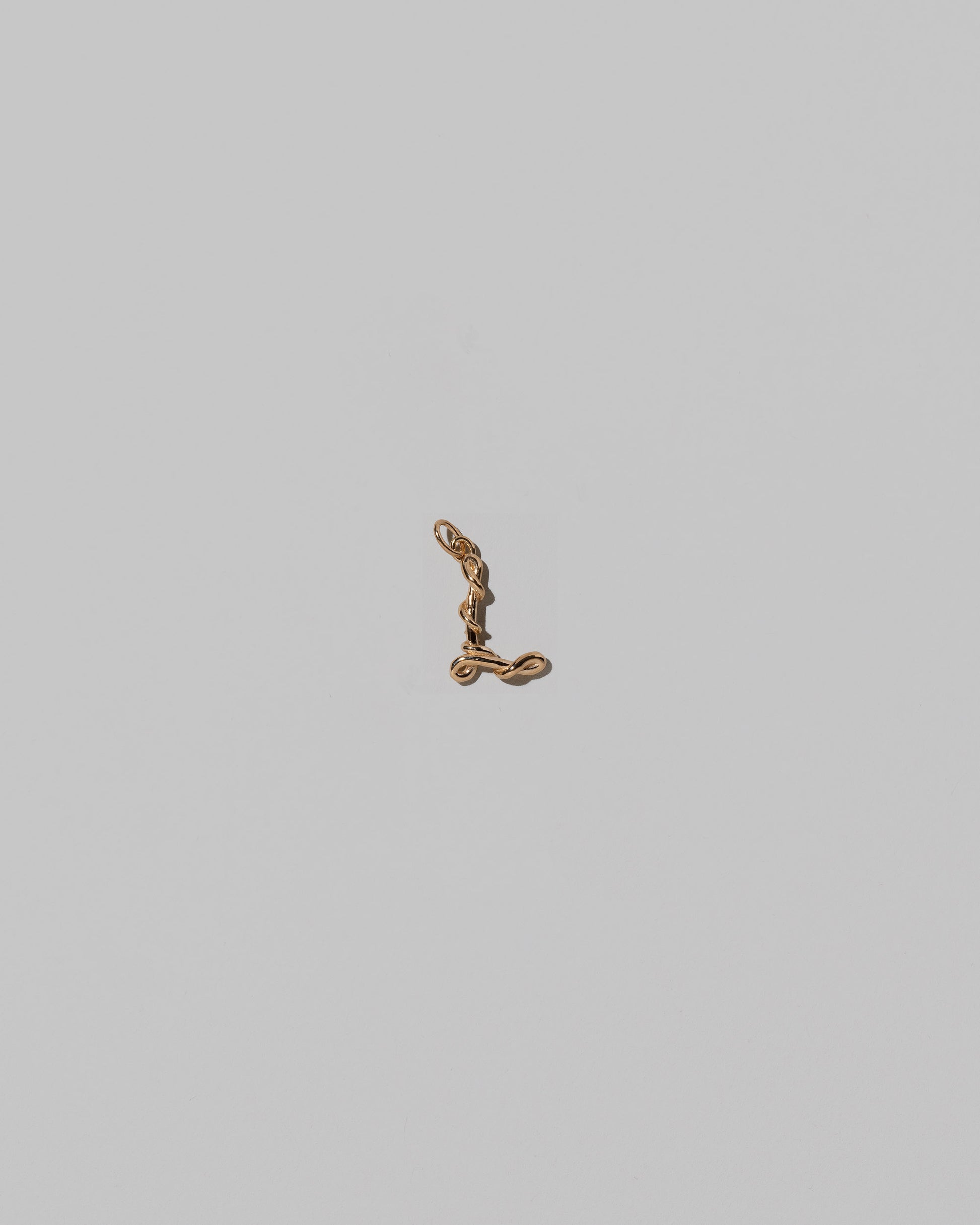 CRZM Mini Letter L set in solid gold on light color background.