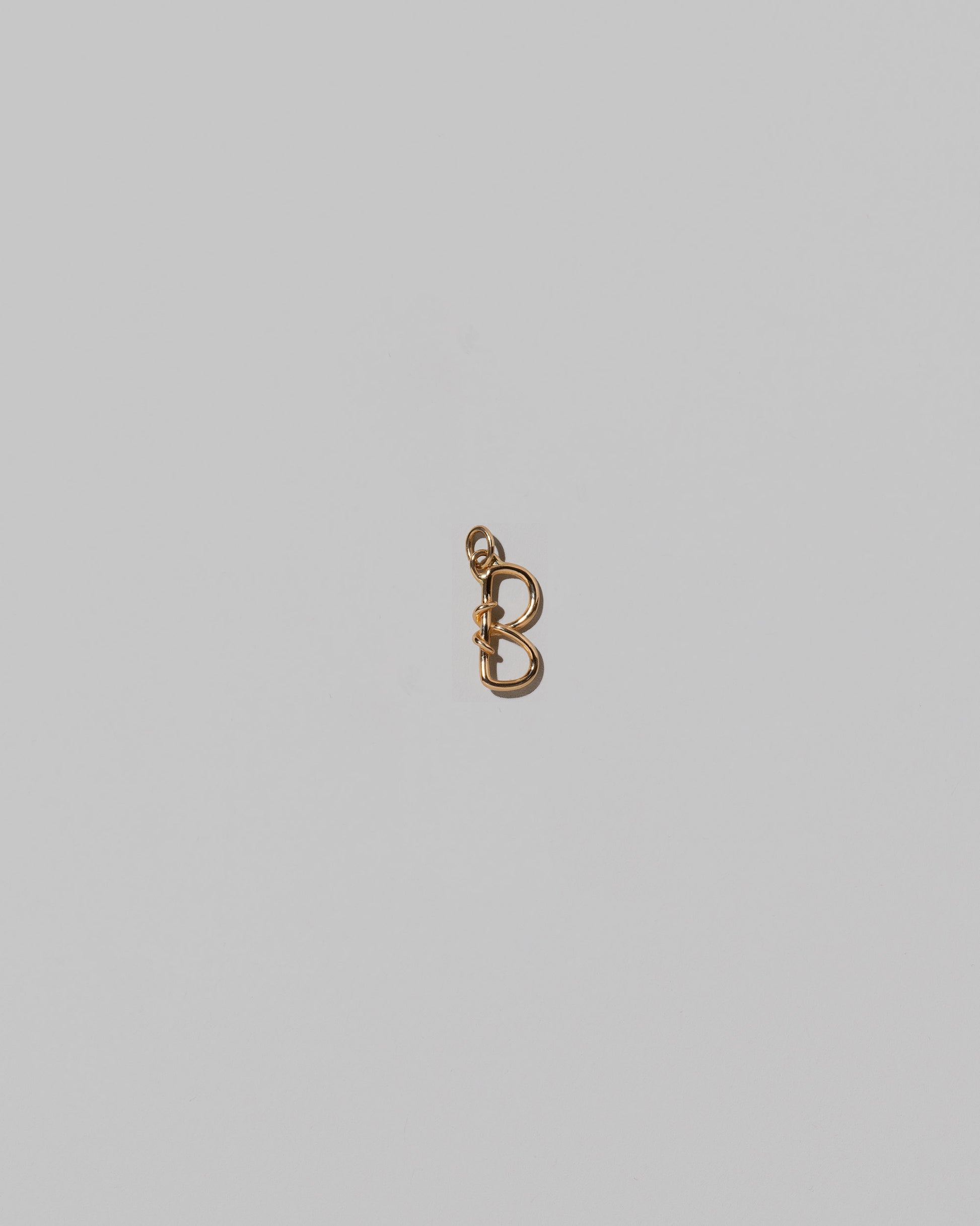 CRZM Mini Letter B set in solid gold on light color background.