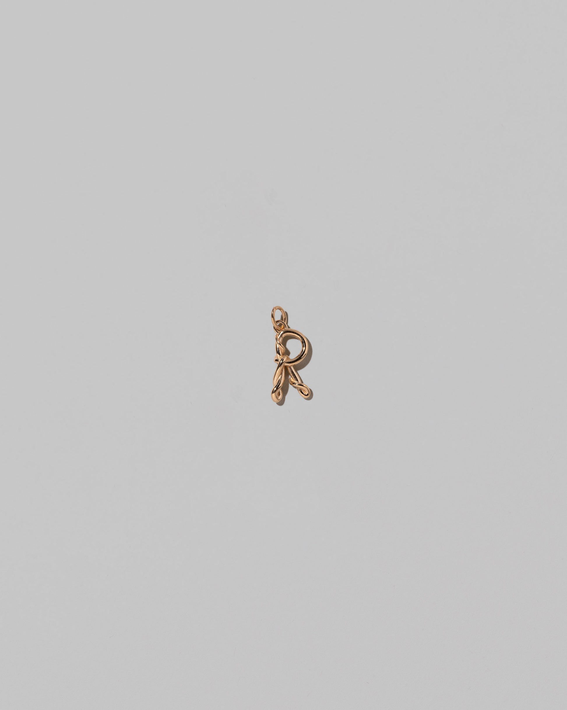 CRZM Mini Letter R set in solid gold on light color background.