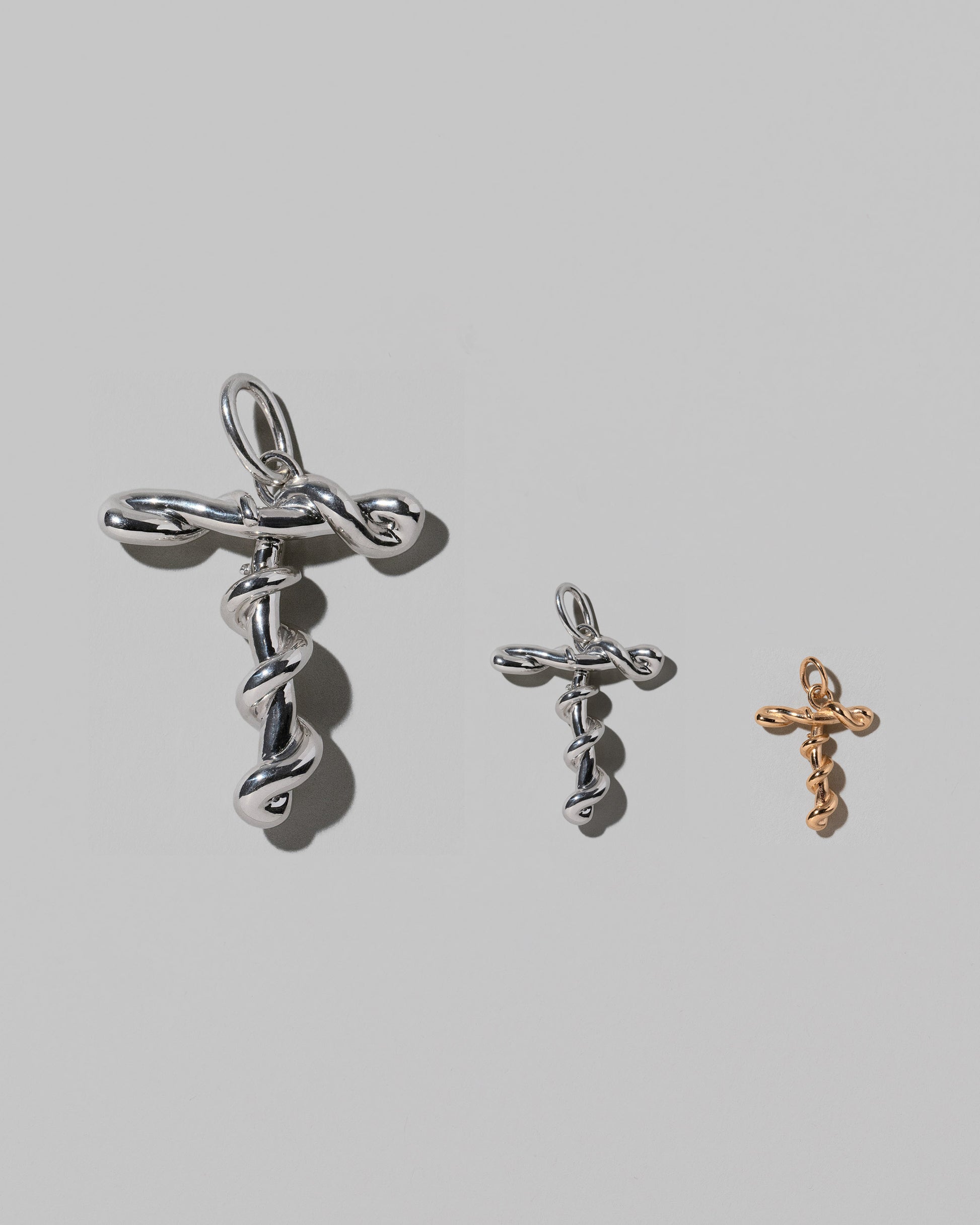 CRZM Large Sterling Silver, Medium Sterling Silver & Mini Letter T Charms set in solid gold on light color background.