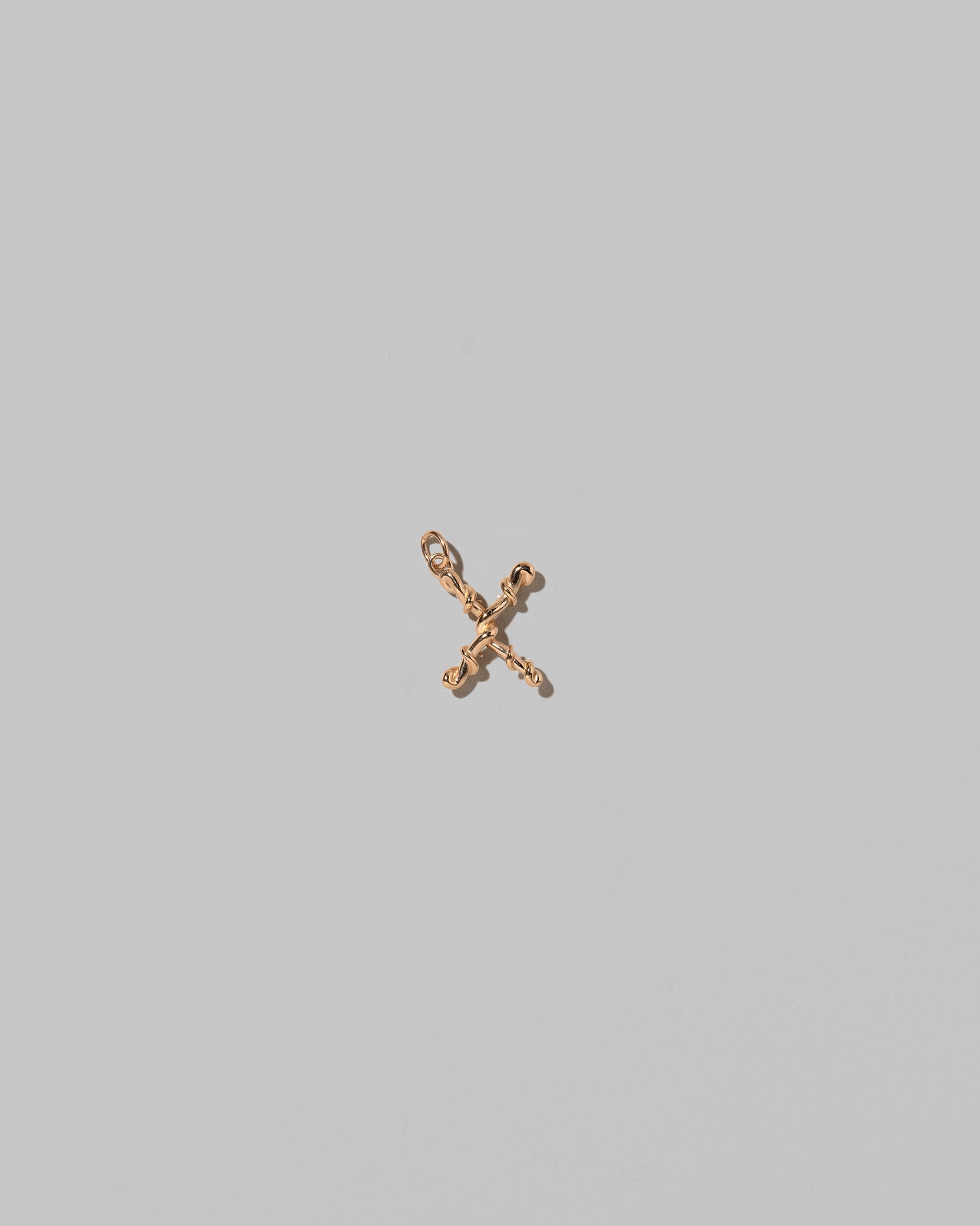 CRZM Mini Letter X set in solid gold on light color background.