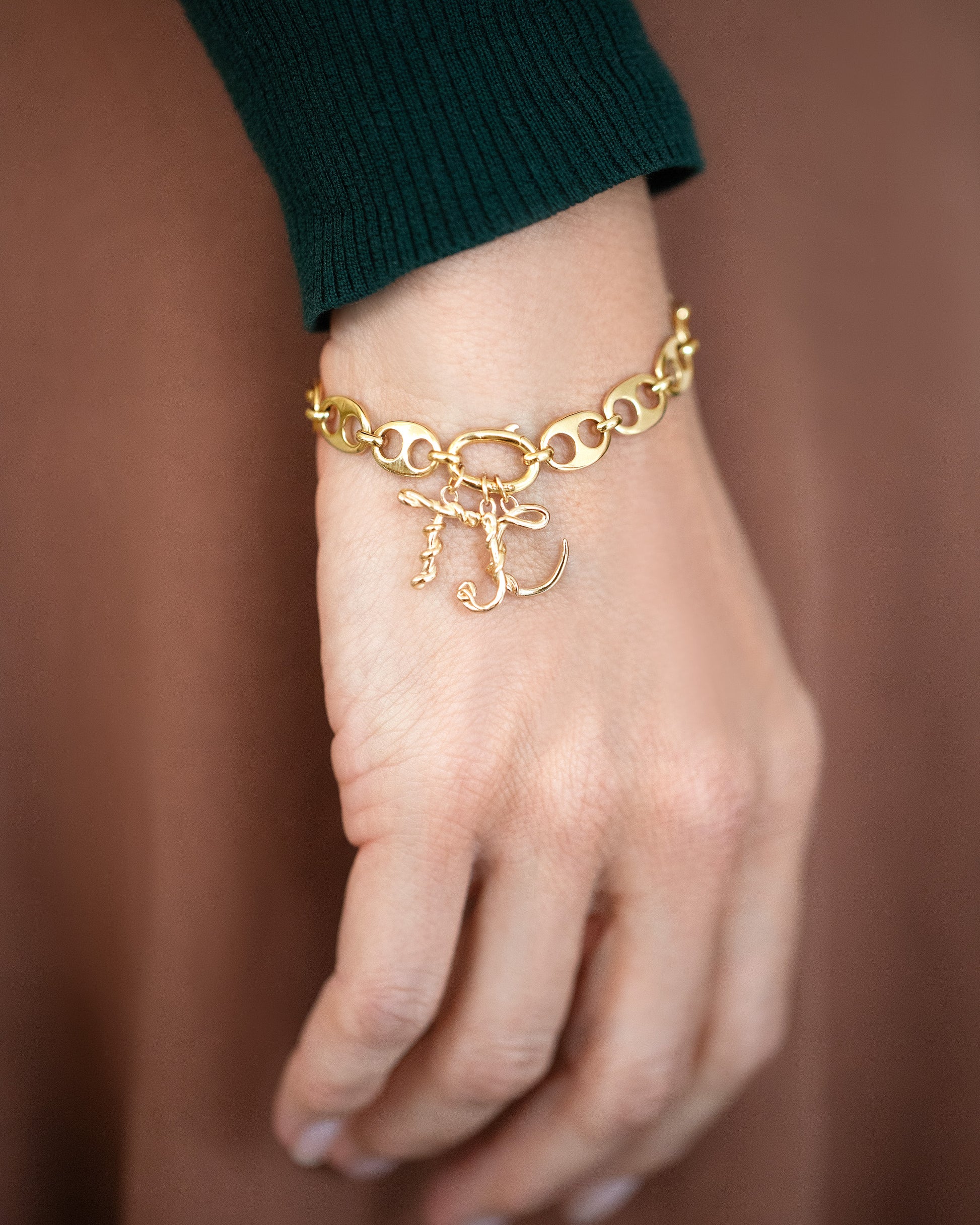 CRZM Solid Gold Mini Yuba Bracelet and CRZM Solid Gold Mini Letter T, J and C Charms on light color model.