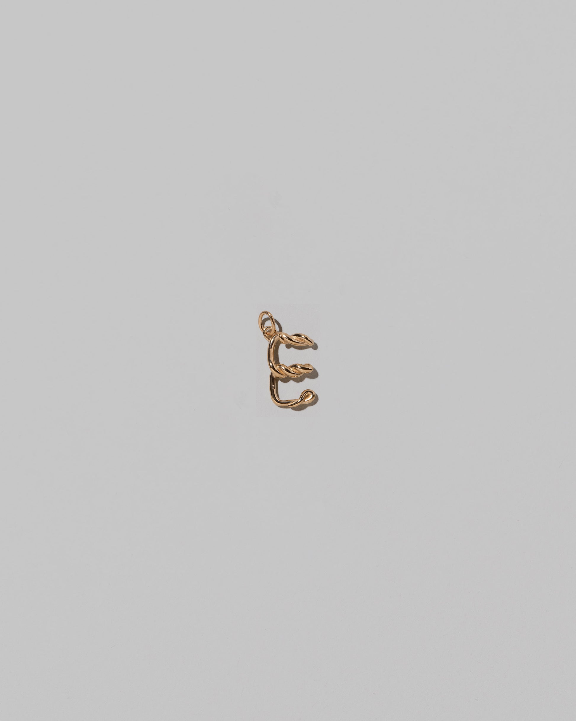 CRZM Mini Letter E set in solid gold on light color background.