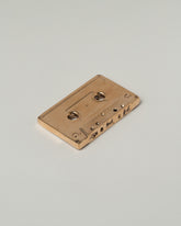 Pearce Objects Cast Bronze Mix Tape on light color background.