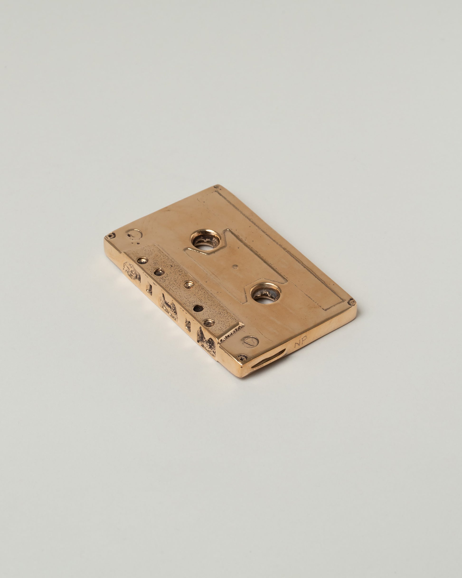 View from the back of the Pearce Objects Cast Bronze Mix Tape on light color background.