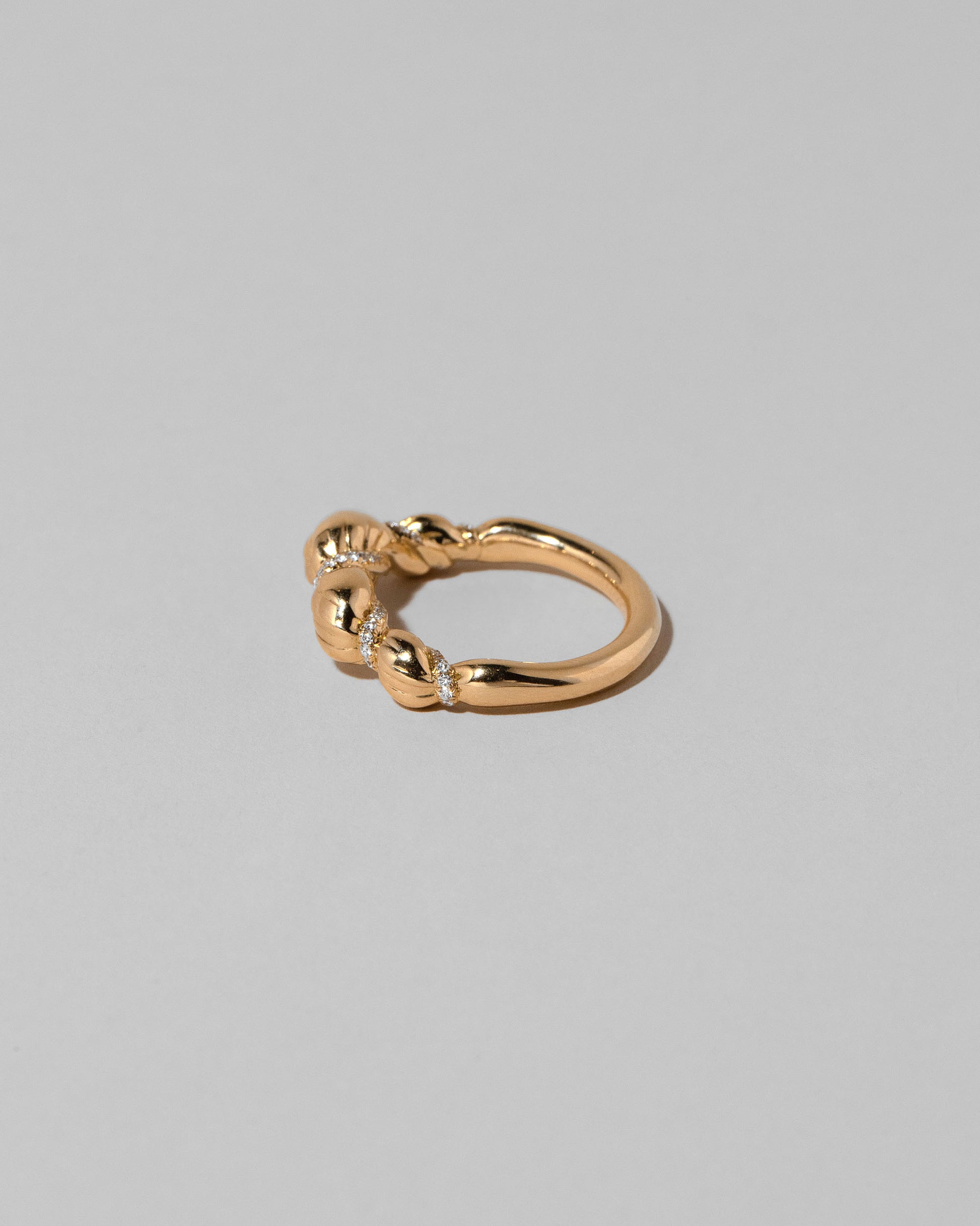 View from the side of the Gold Pavé Bind Band on light color background.