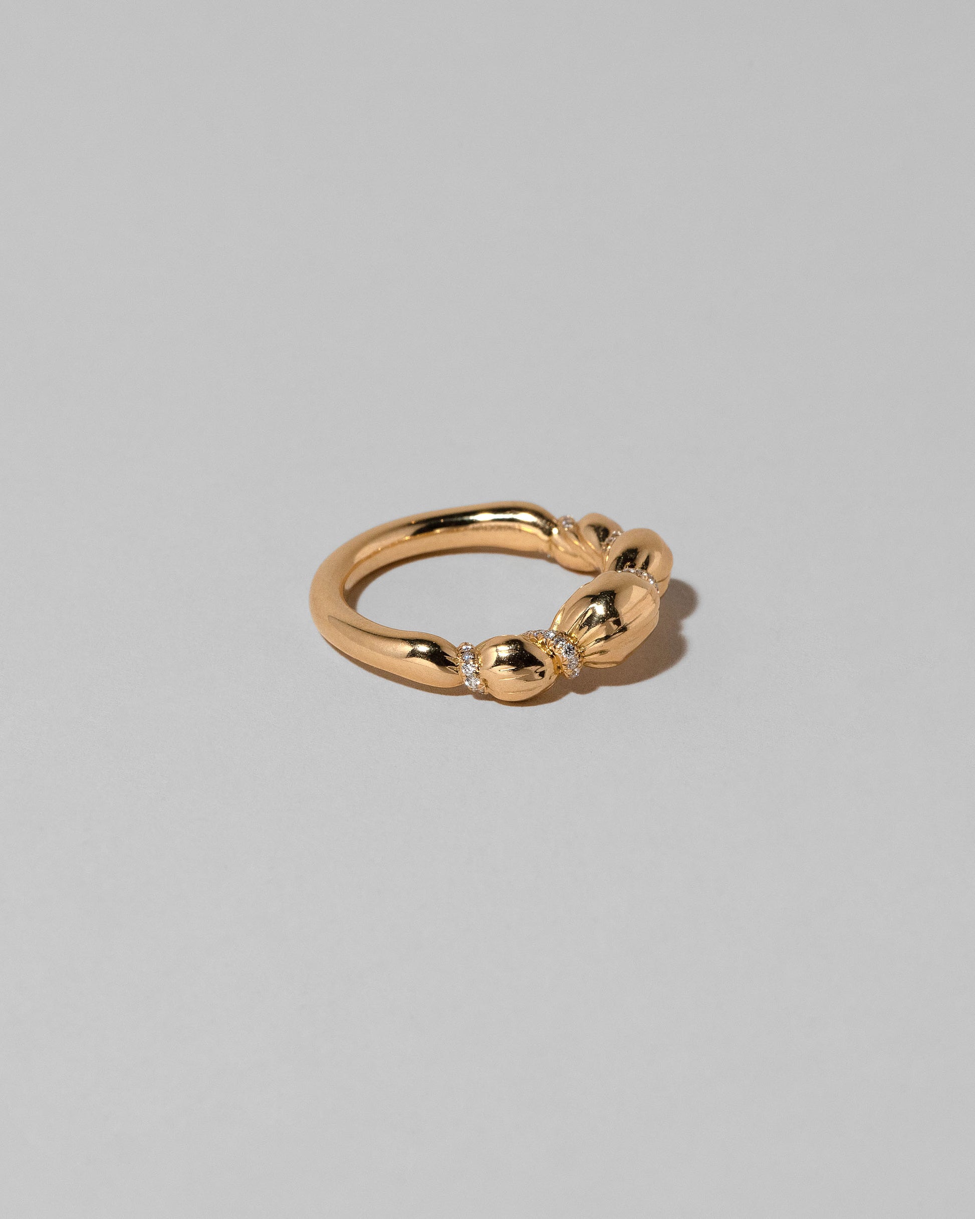 View from the side of the Gold Pavé Bind Band on light color background.
