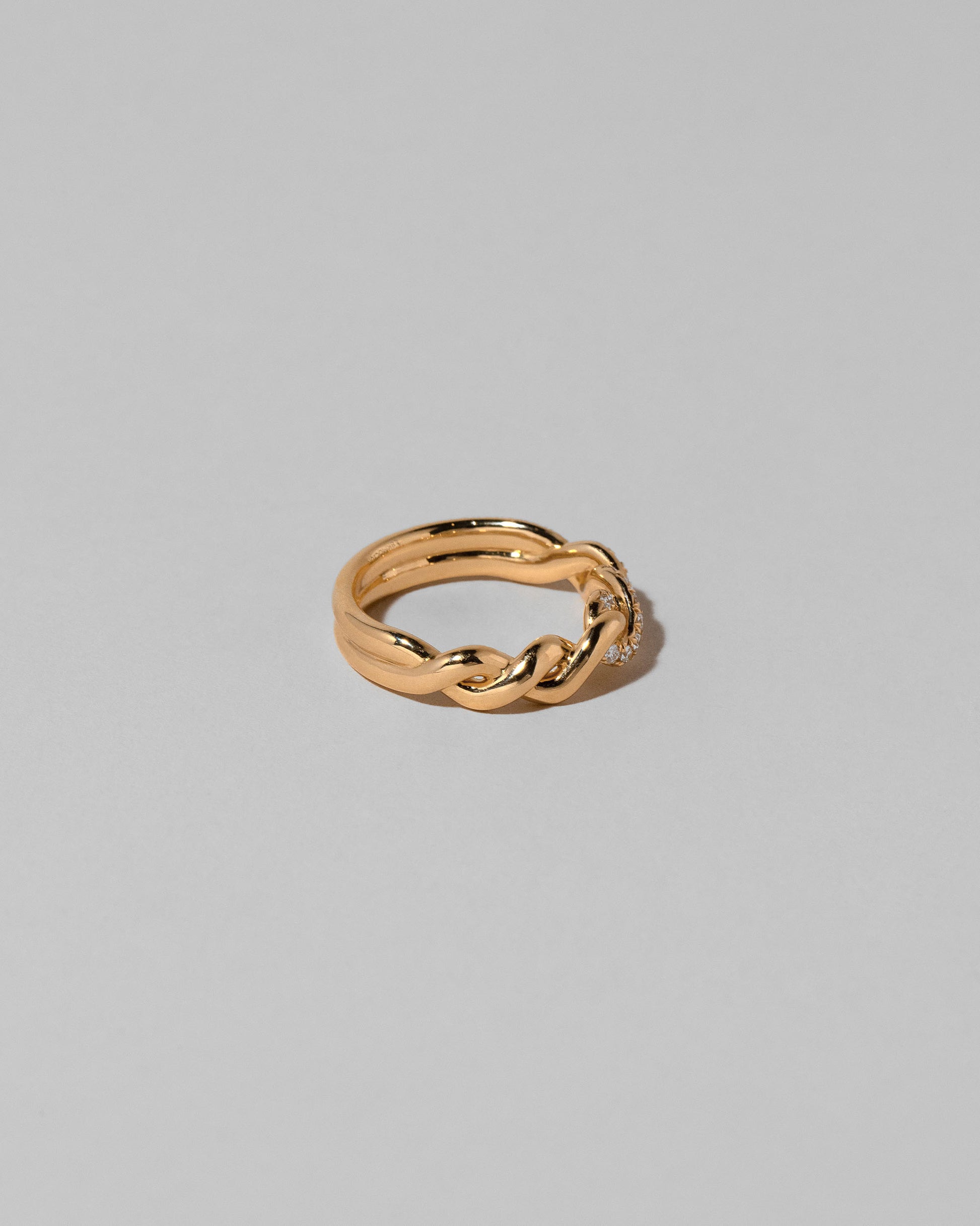 View from the side of the Gold Pavé Twist Band on light color background.