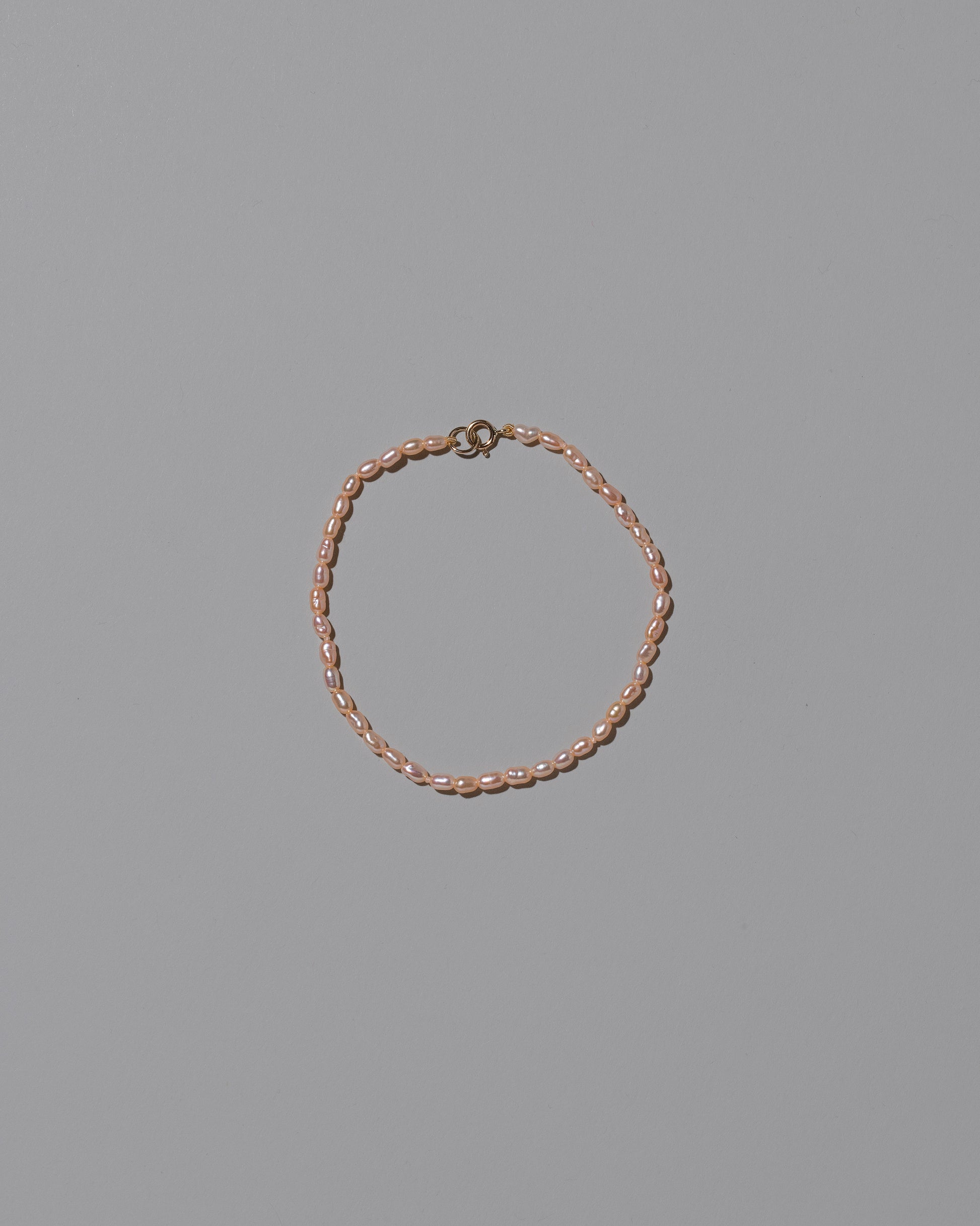 Pink Oval Seed Pearl Bracelet on light color background.