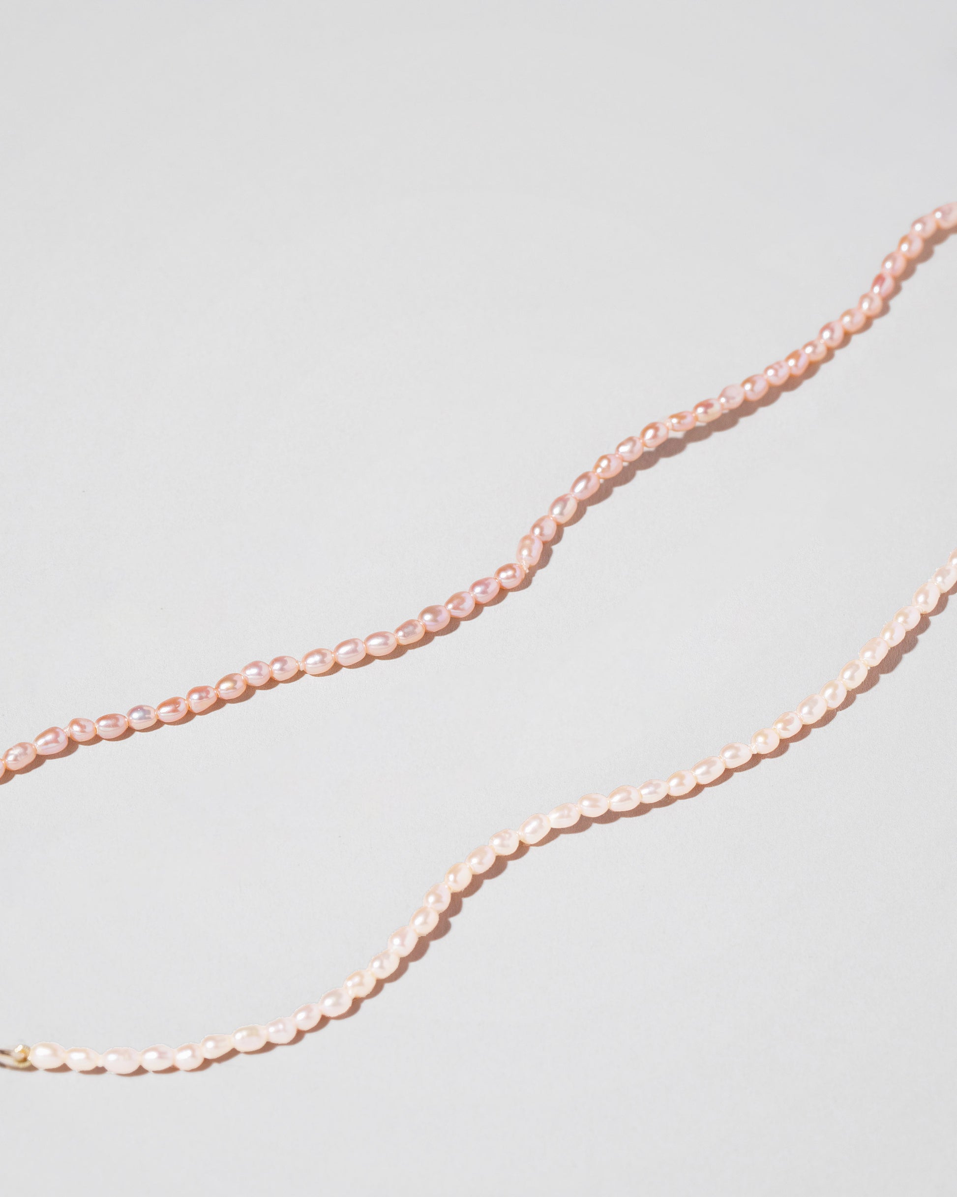 Closeup details of the Pink Oval Seed Pearl Bracelets on light color background.