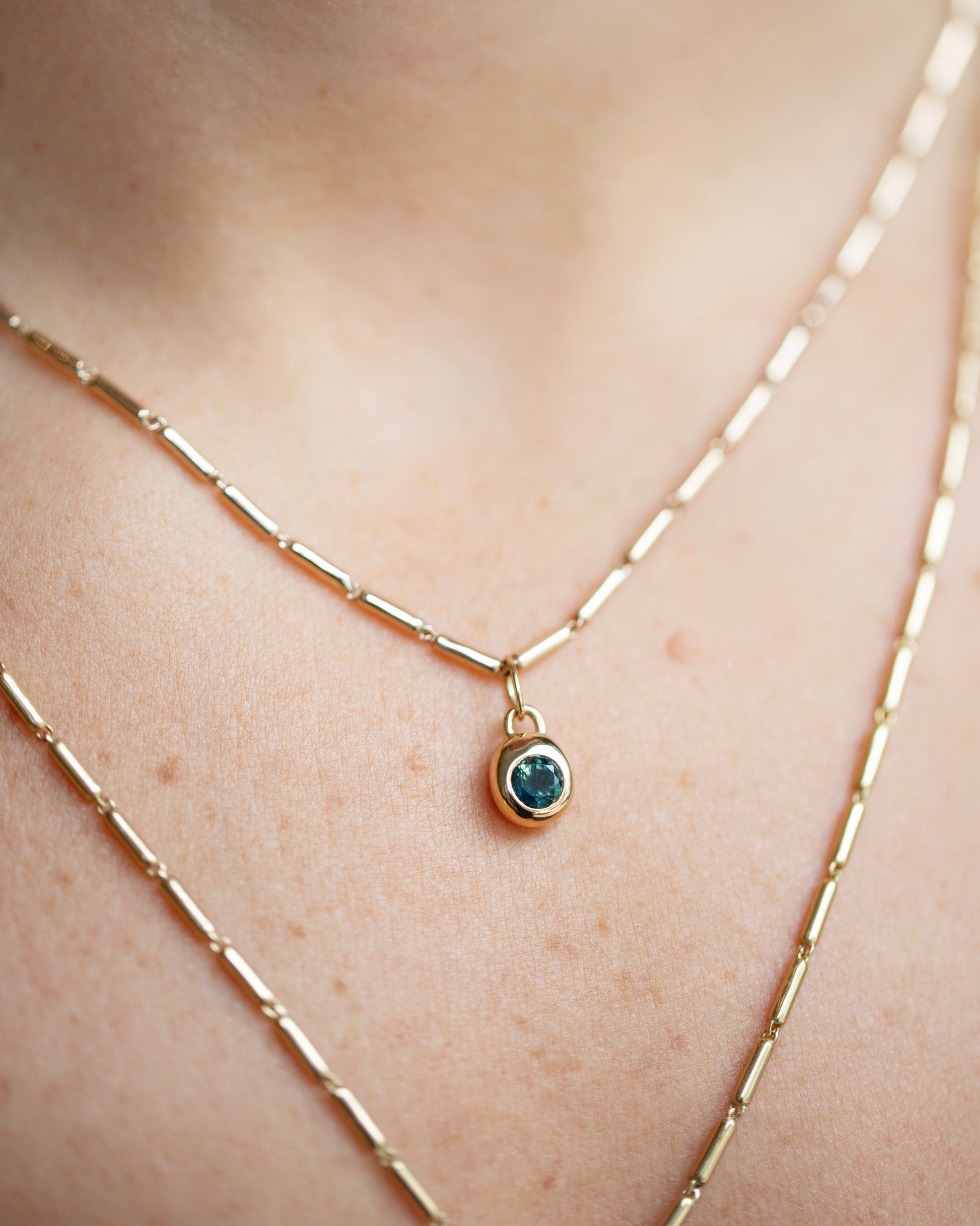 Gold Butter Chain Necklace and Bicolor Sapphire Birthstone Level Charm on model.