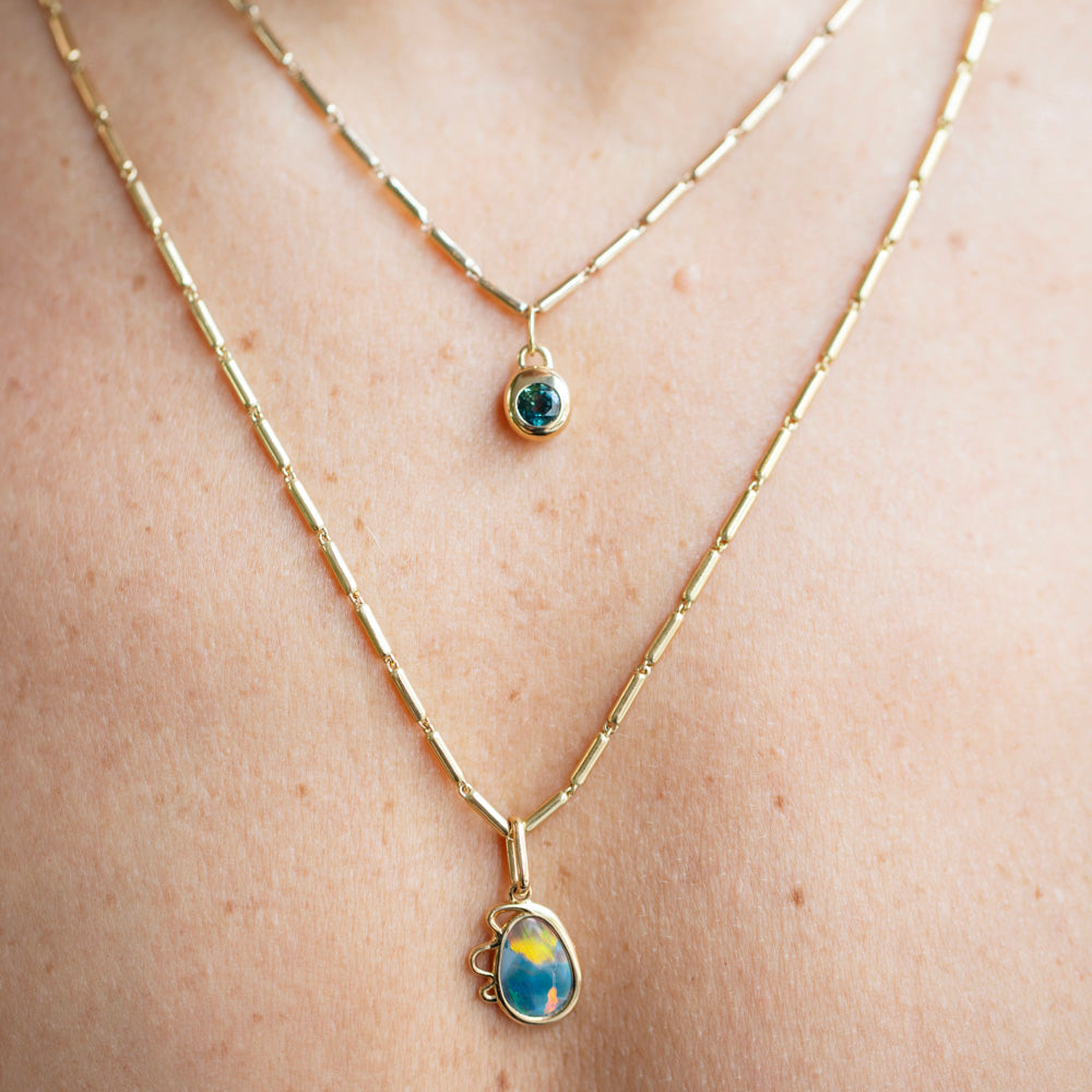 product_details::Gold Butter Chain Necklace, Harmony Pendant and Bicolor Sapphire Birthstone Level Charm on model.