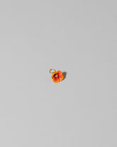 Closeup details of the California Poppy Charm on light color background.