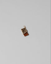 Closeup details of the Chocolate Bar Charm on light color background.