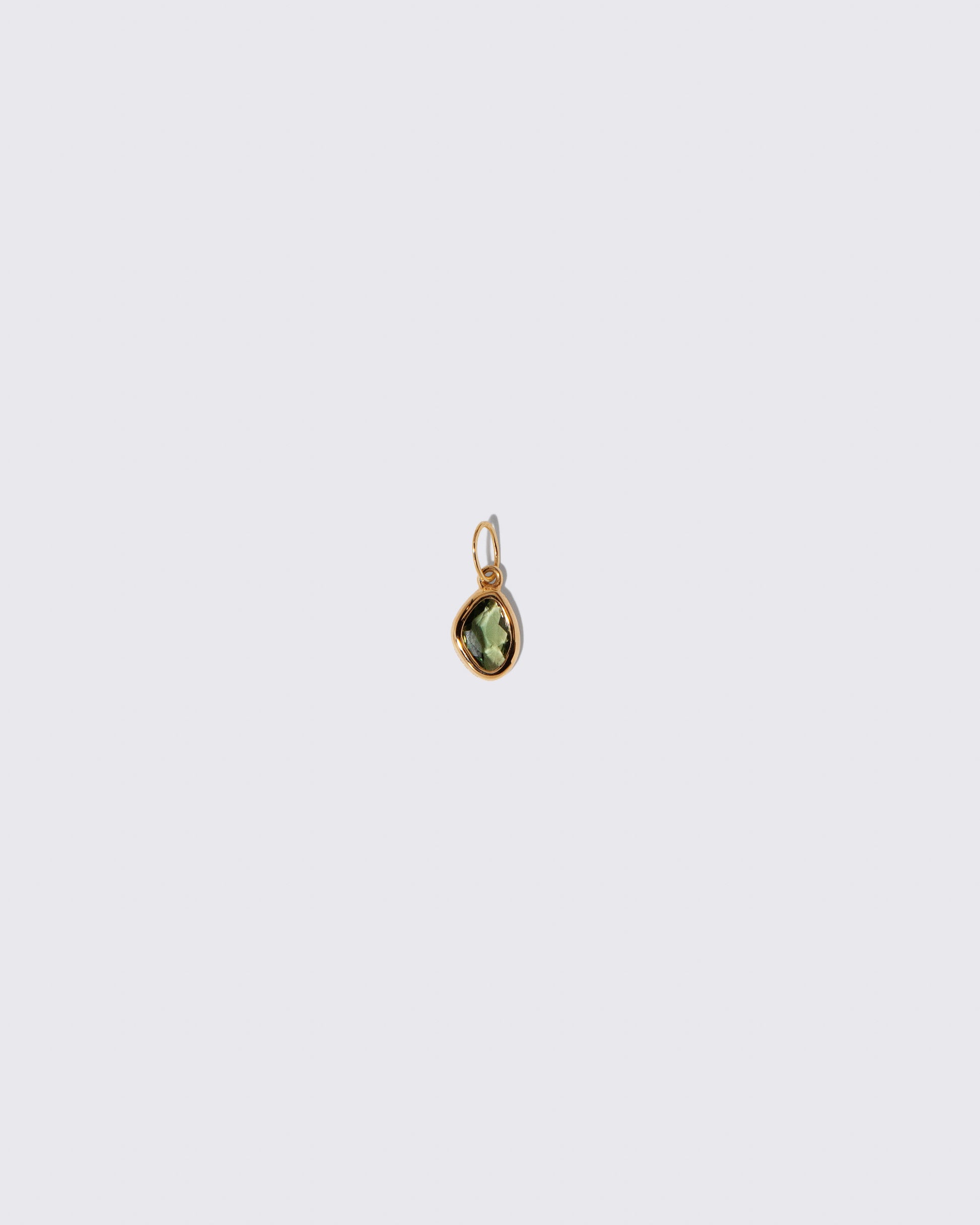 Green Sapphire Gusher Charm on light color background.