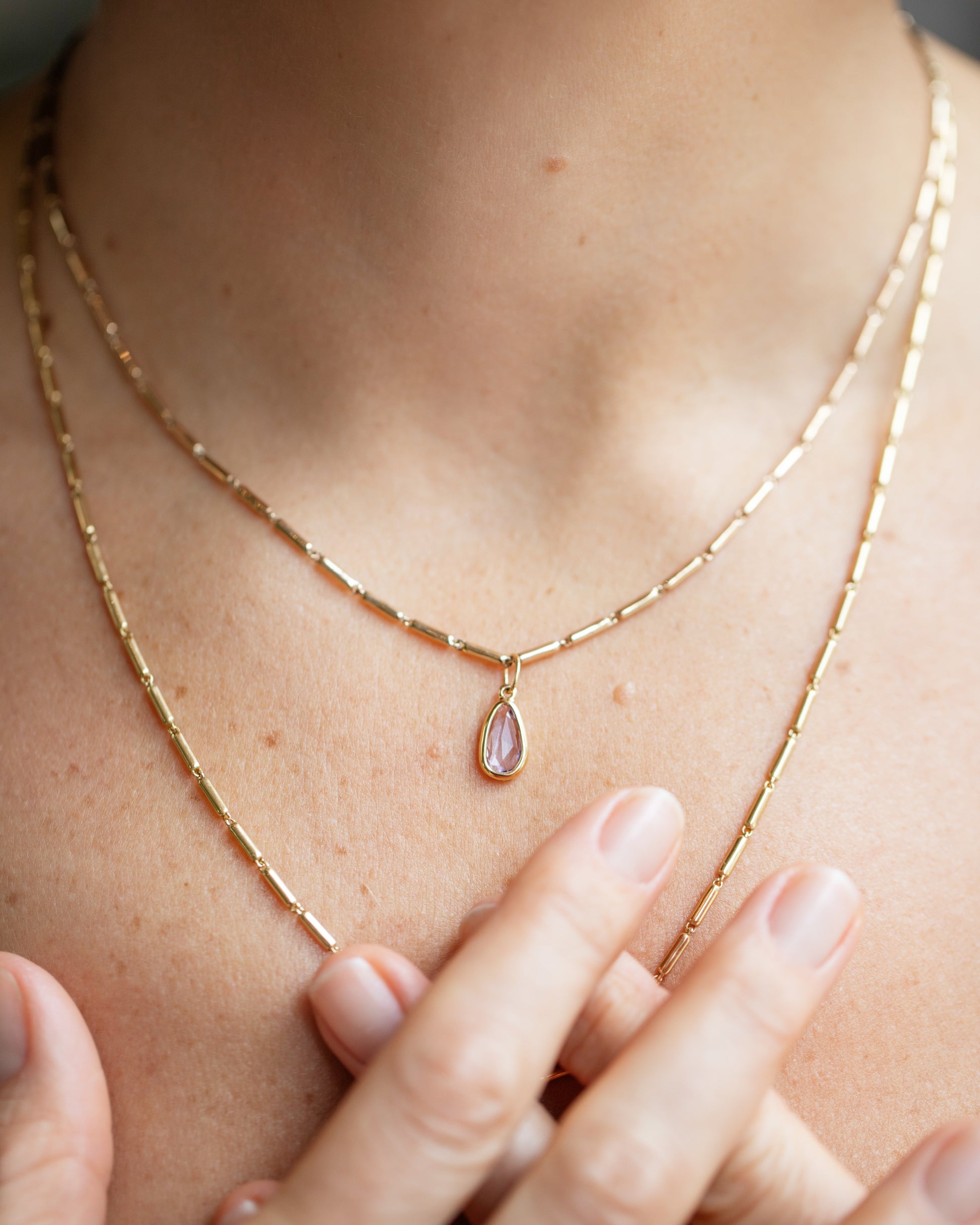 Purple Sapphire Gusher Charm and Gold Butter Chain Necklace on model.