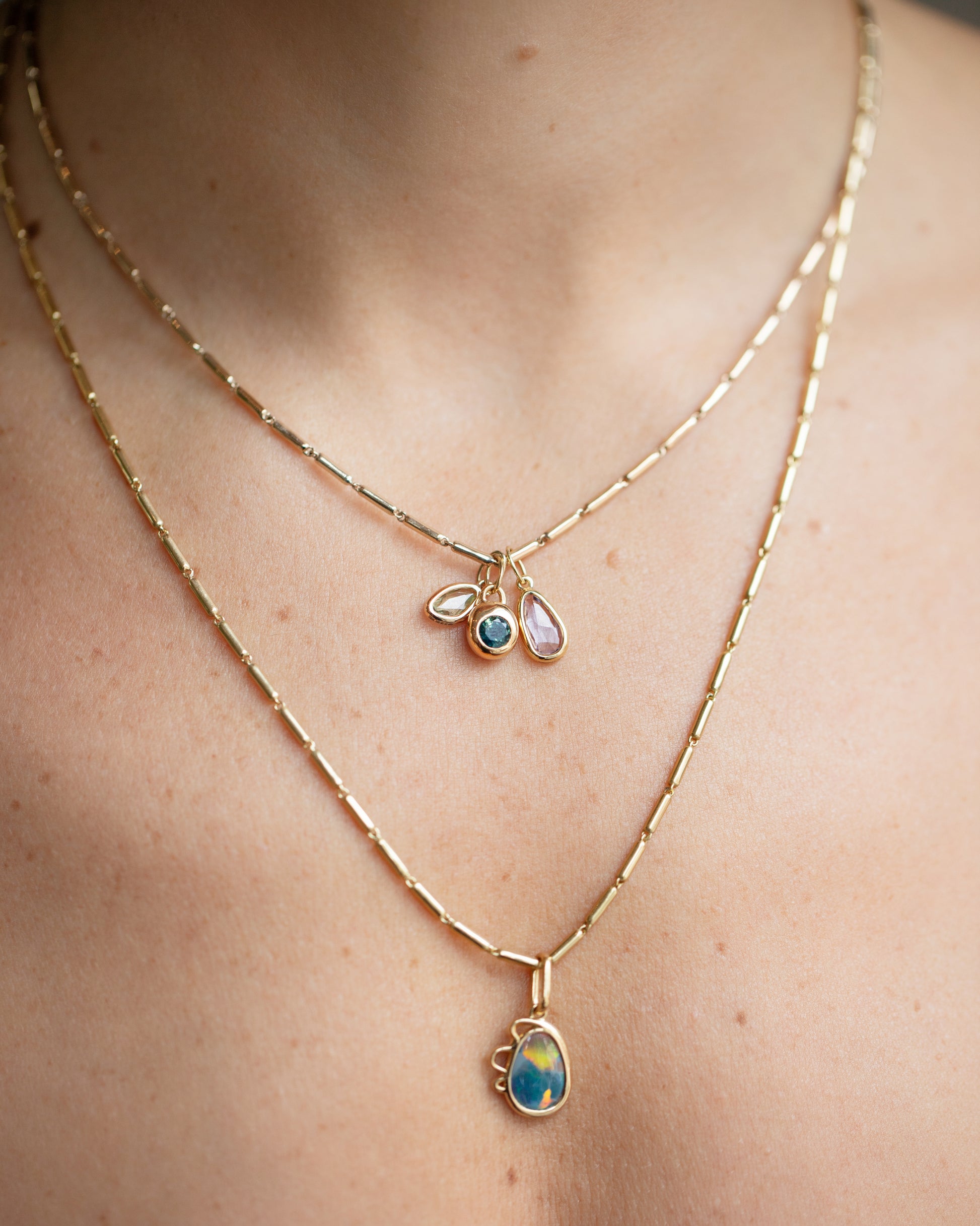 Harmony Pendant, Sapphire Birthstone Level Charm and Purple and Yellow Sapphire Gusher Charm with Gold Butter Chain Necklaces on model.