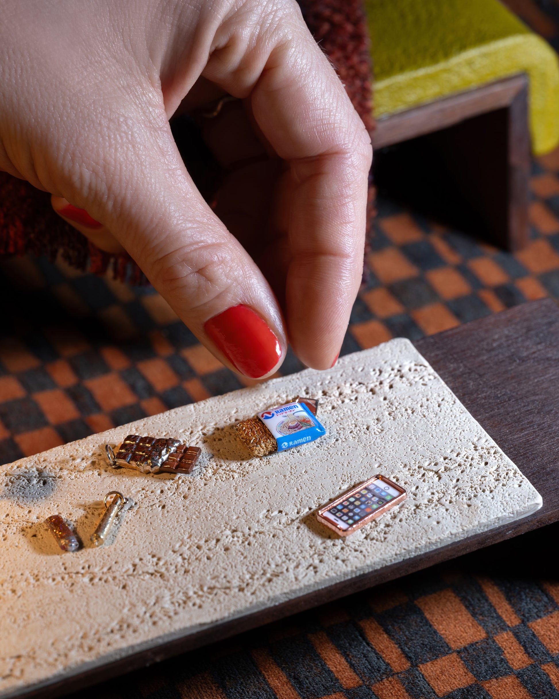 Styled image of the Instant Ramen Charm, with the Joint Charm, Dirty Martini Charm and Chocolate Bar Charm.