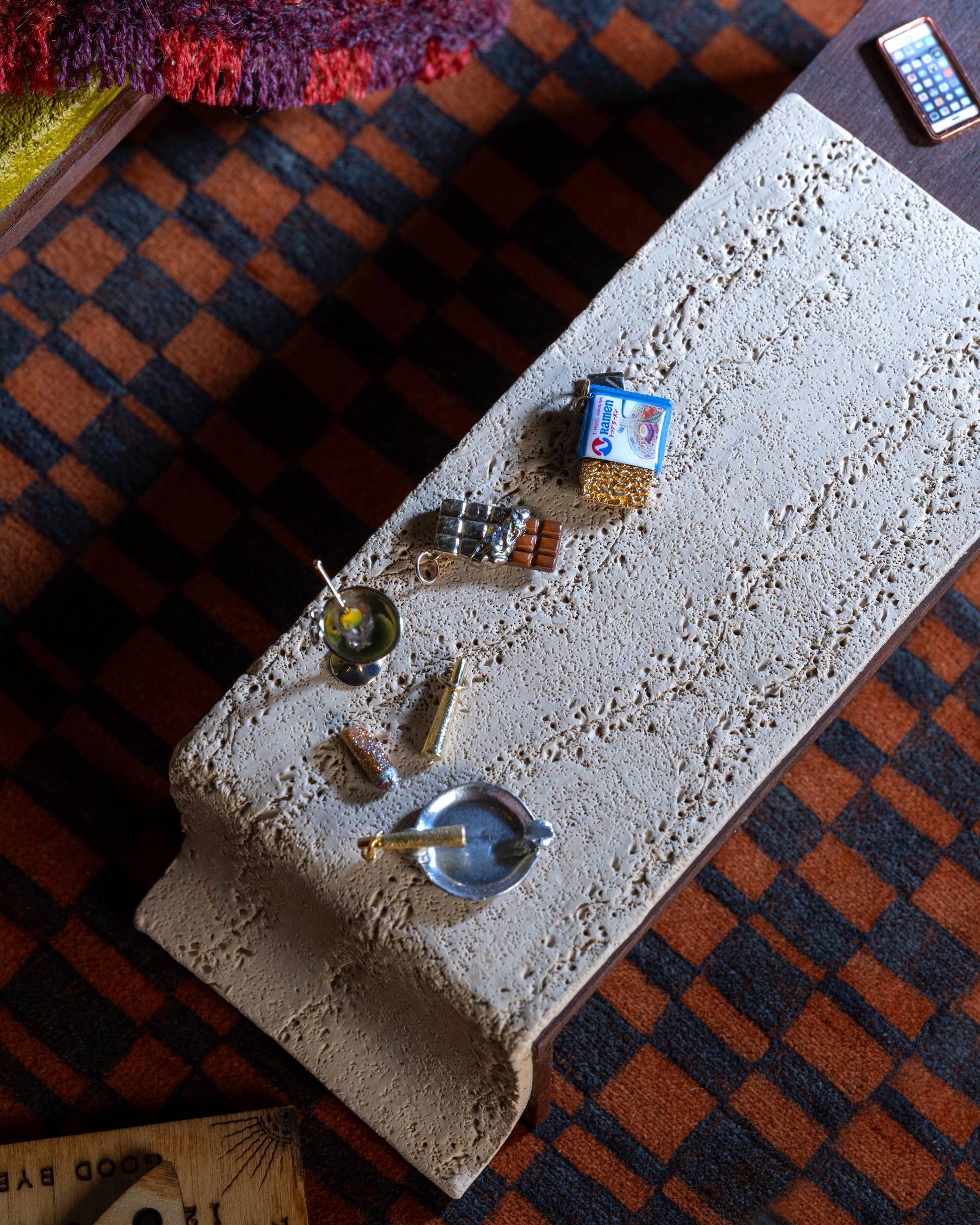 Styled image featuring the Instant Ramen Charm, with the Joint Charm, Lit Joint Charm, Dirty Martini Charm and Chocolate Bar Charm.